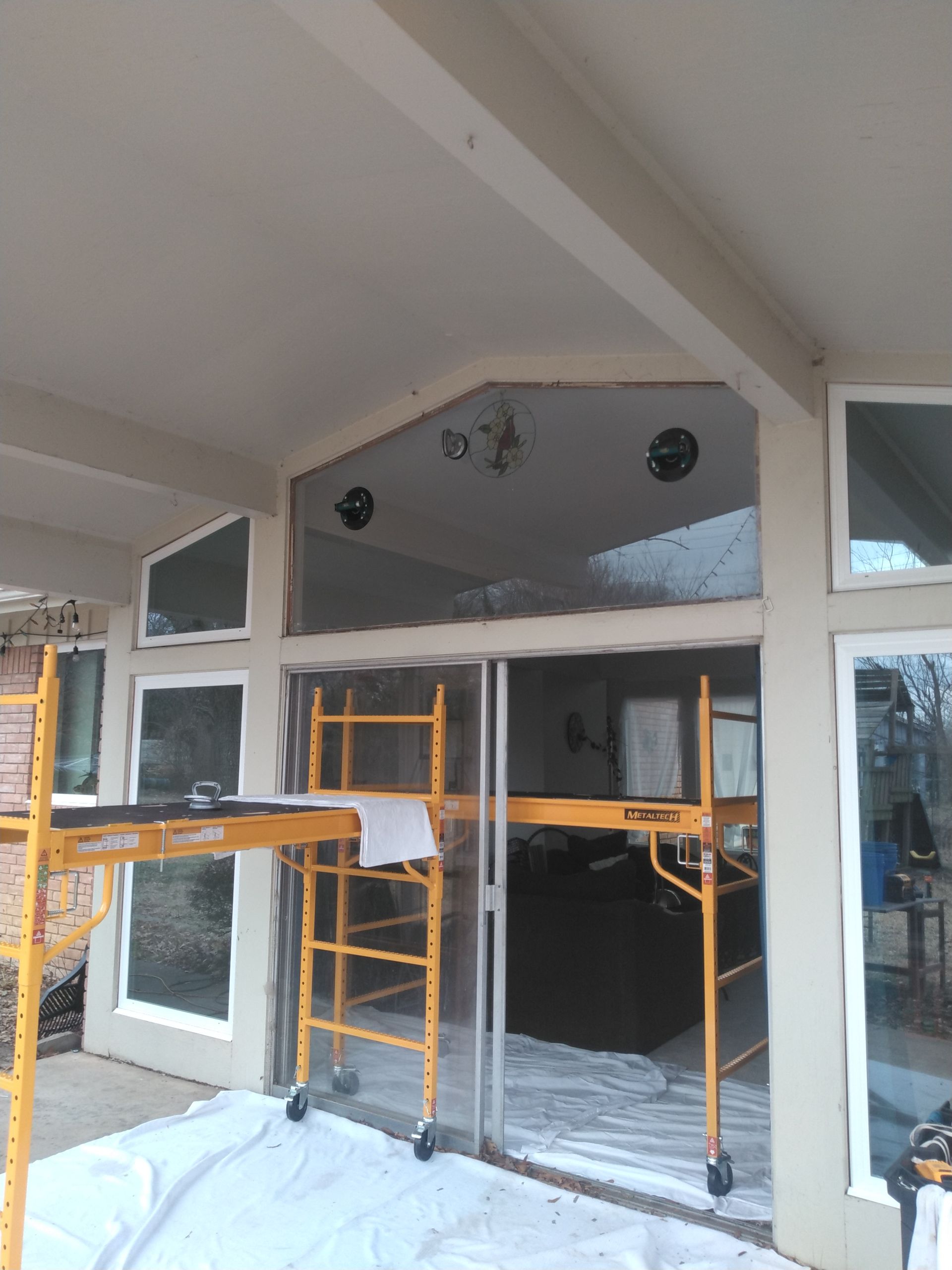 A yellow scaffolding is sitting outside of a house