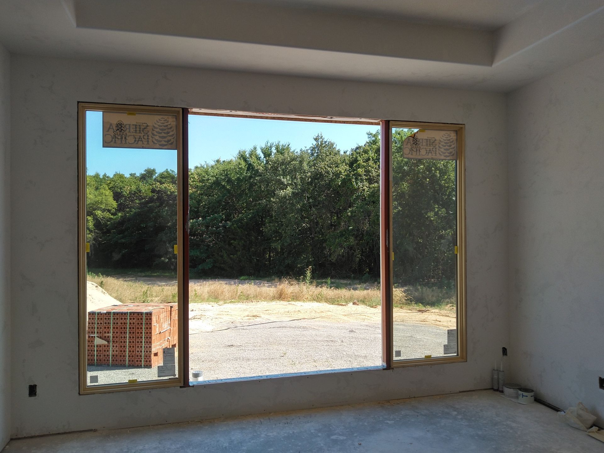 An empty room with a large window looking out to a field