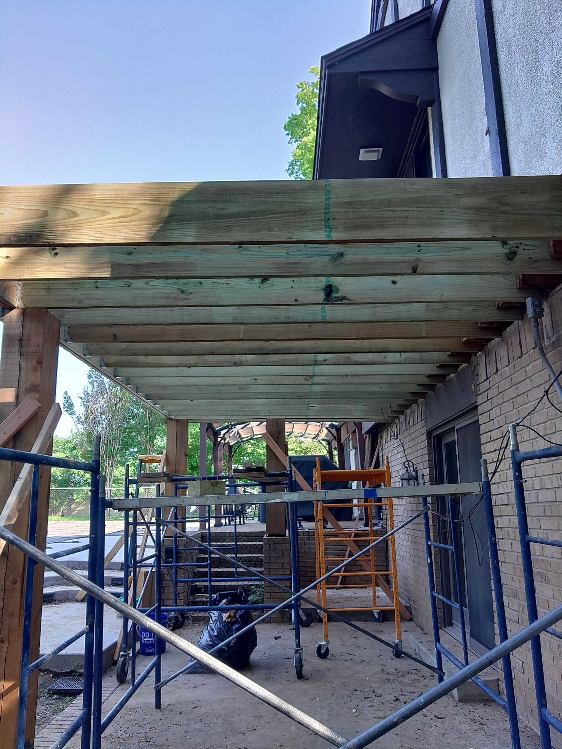 A wooden deck is being built on the side of a building.
