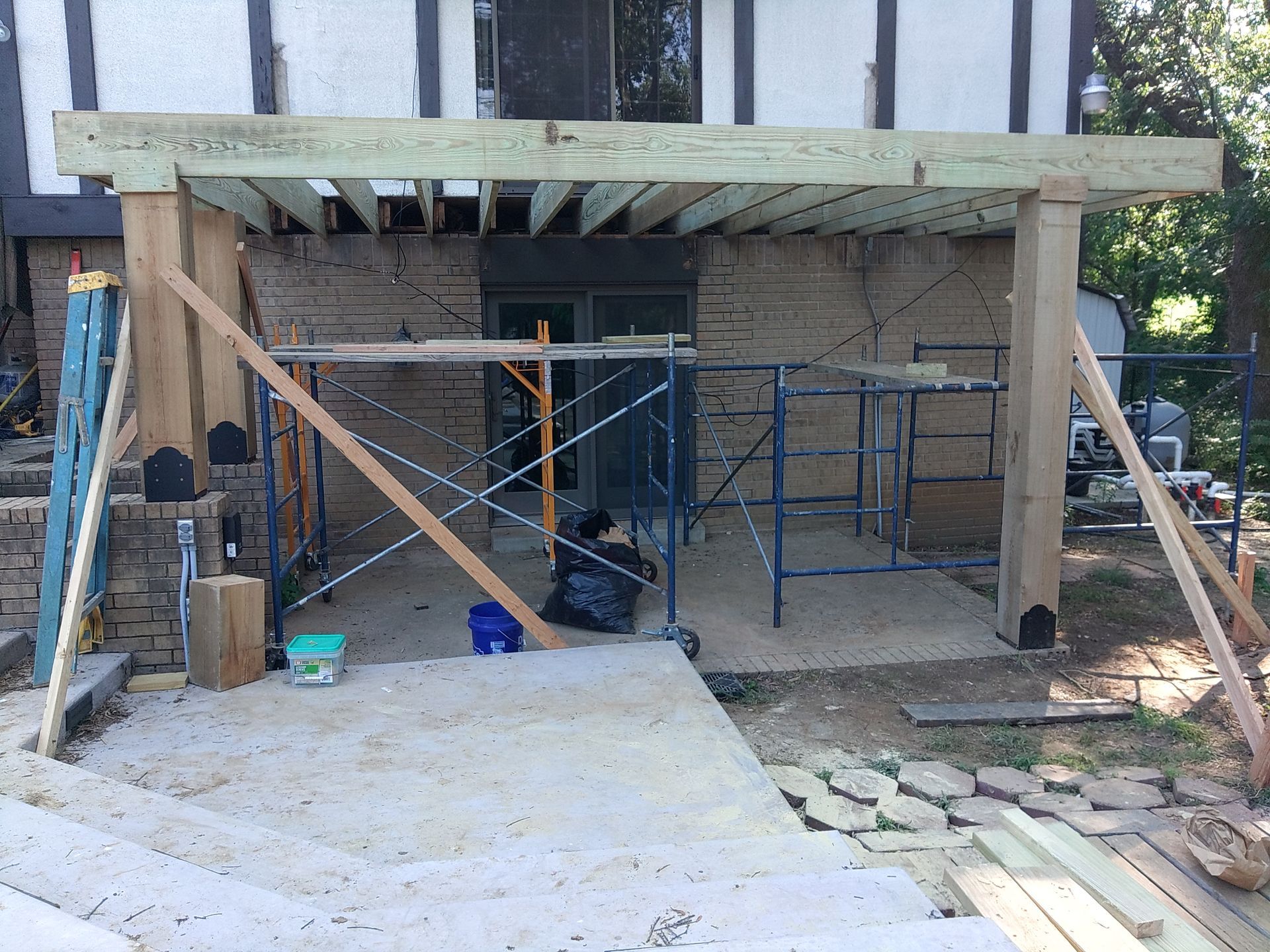 A wooden deck is being built on the side of a house