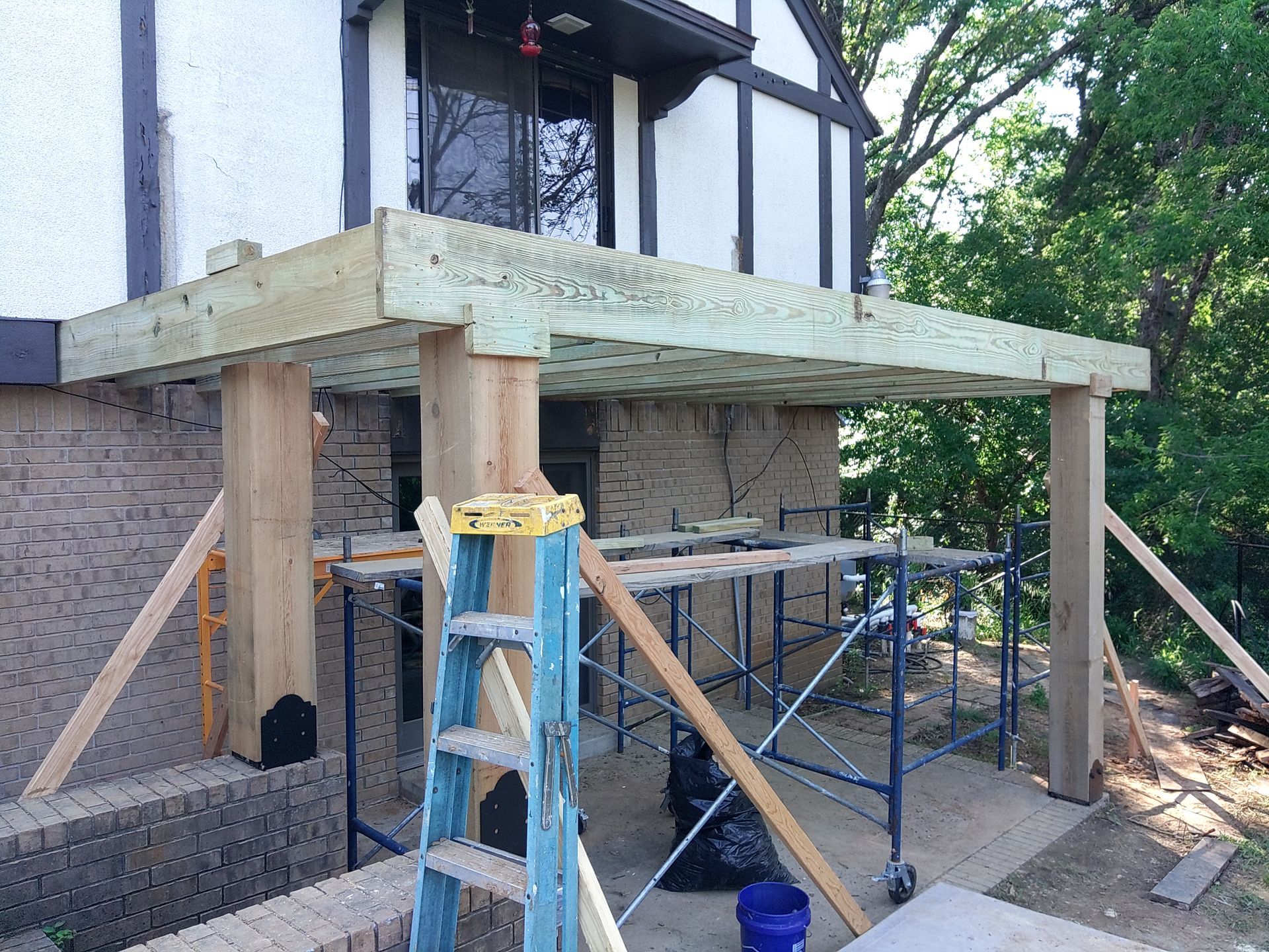 A wooden deck is being built on the side of a house.