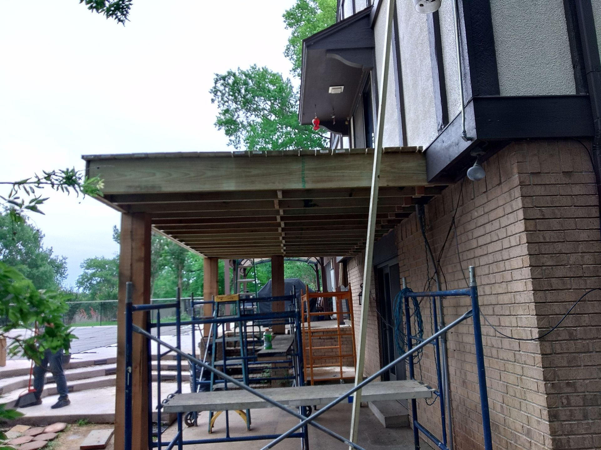 A wooden deck is being built on the side of a house