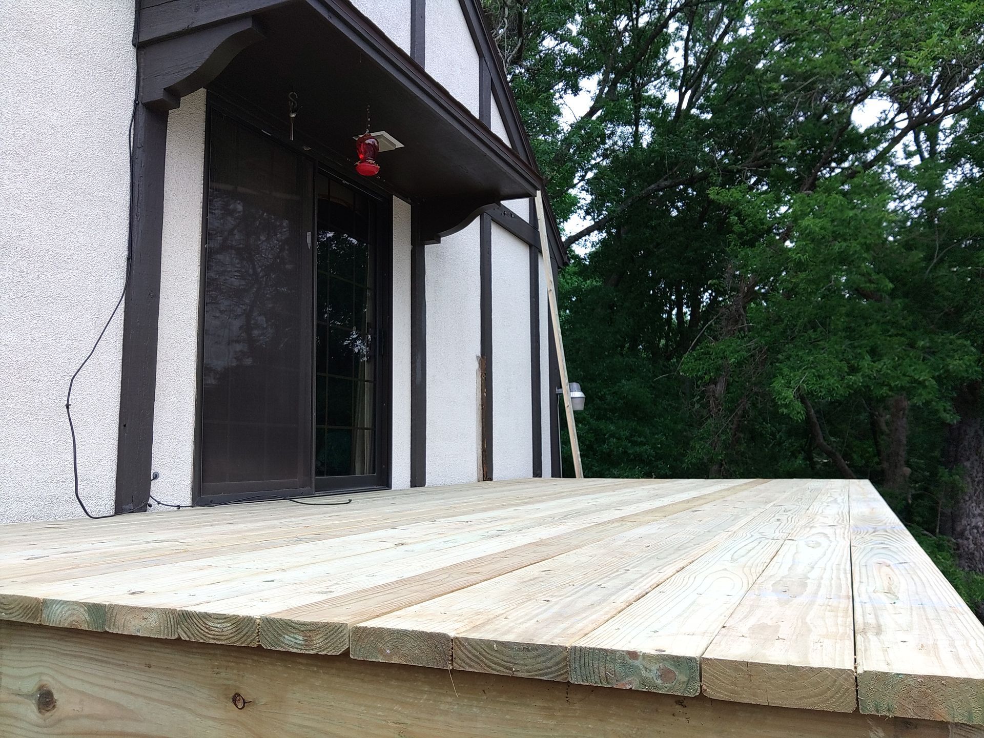A wooden deck is being built in front of a house.