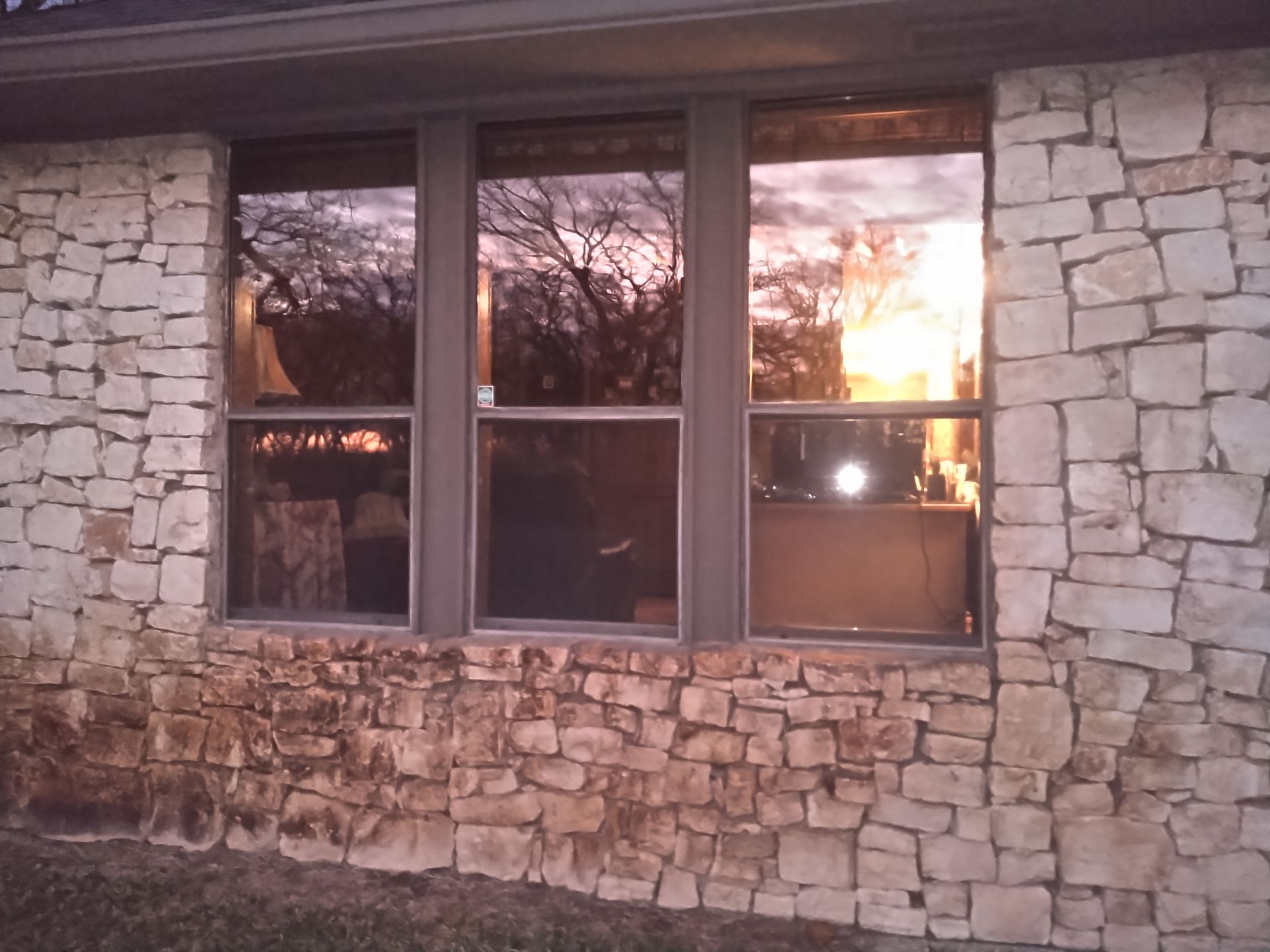 A house with a stone wall and three windows