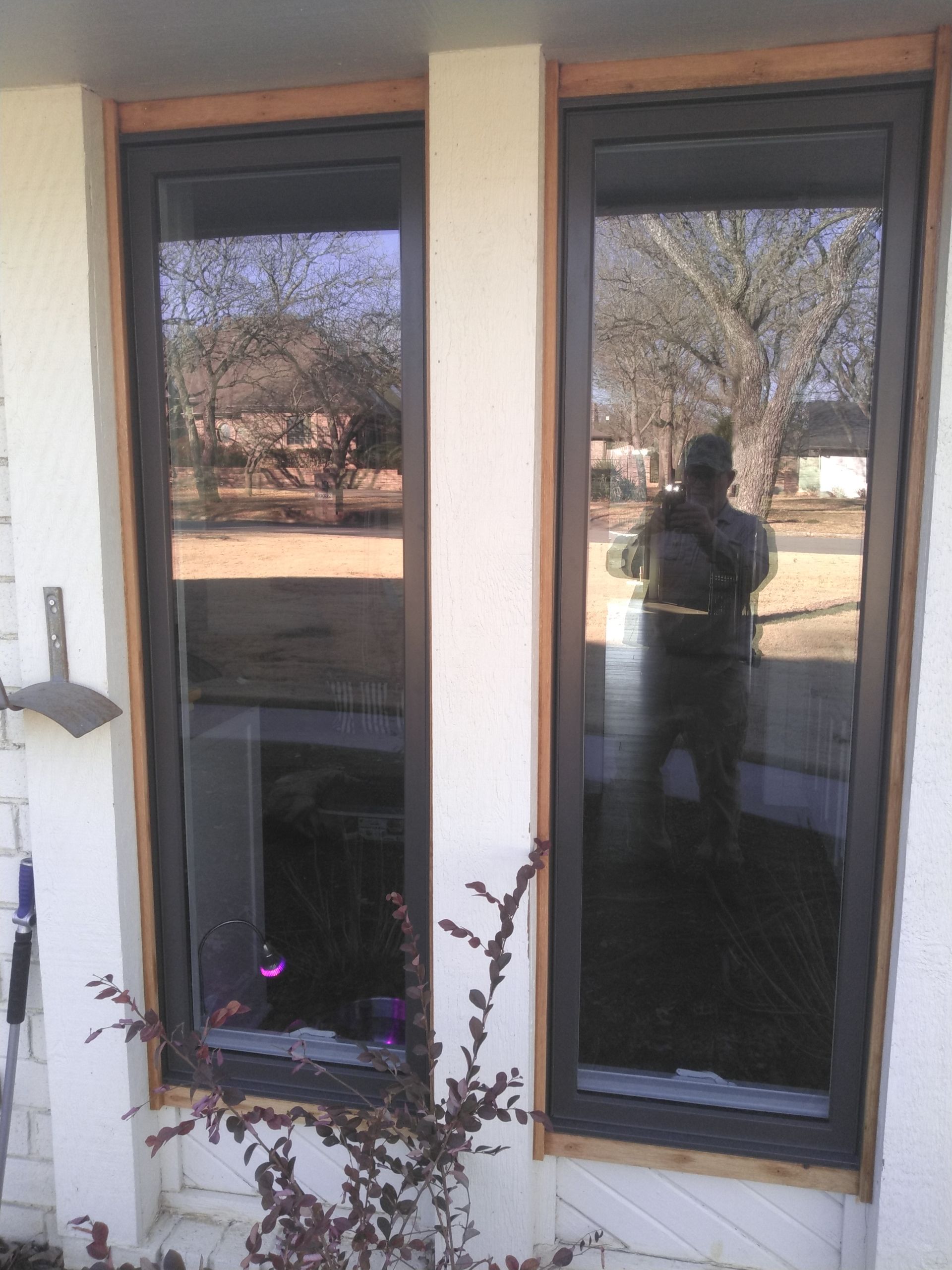 A man is reflected in a window of a house