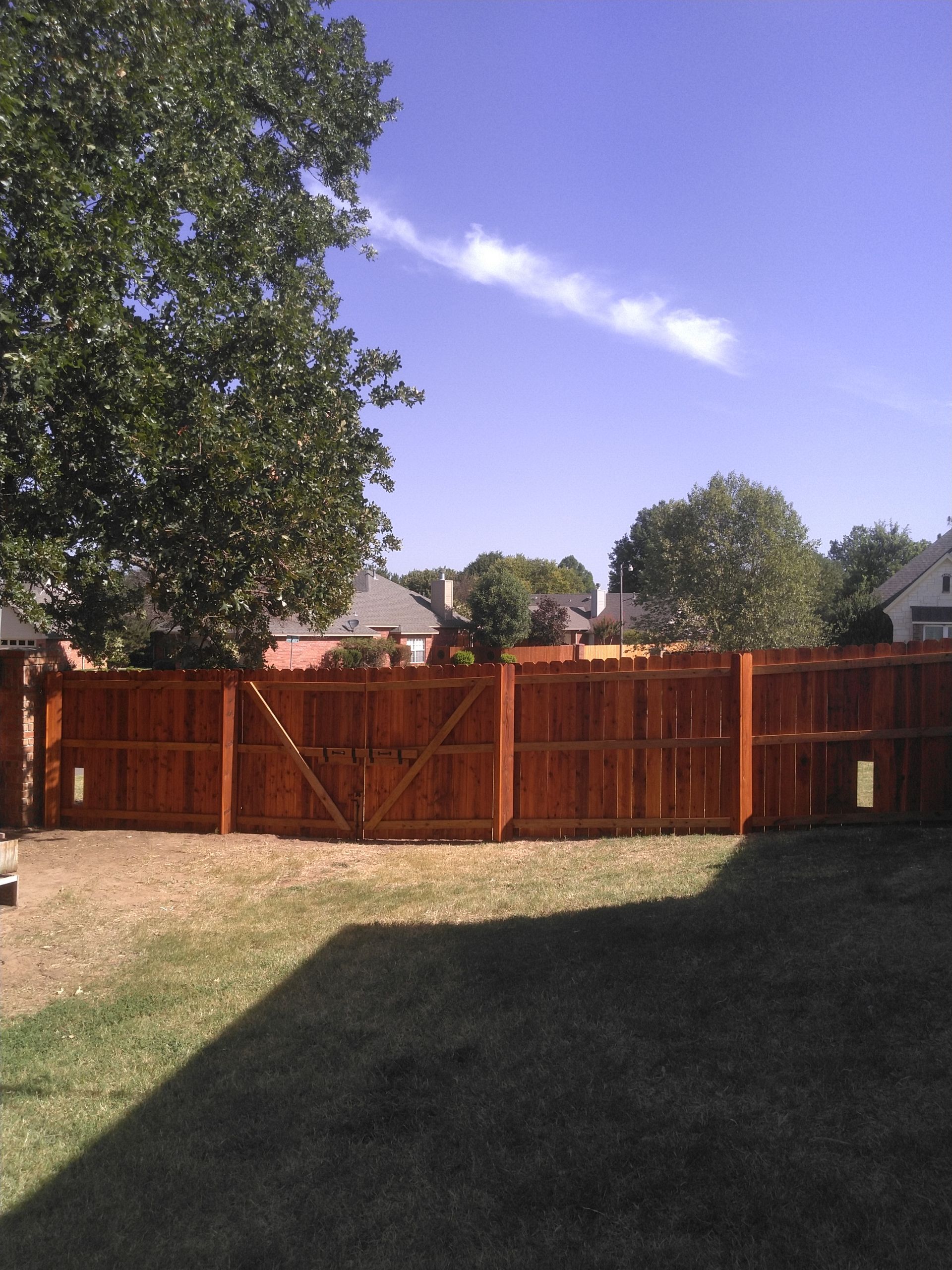 A backyard with a wooden fence and a gate