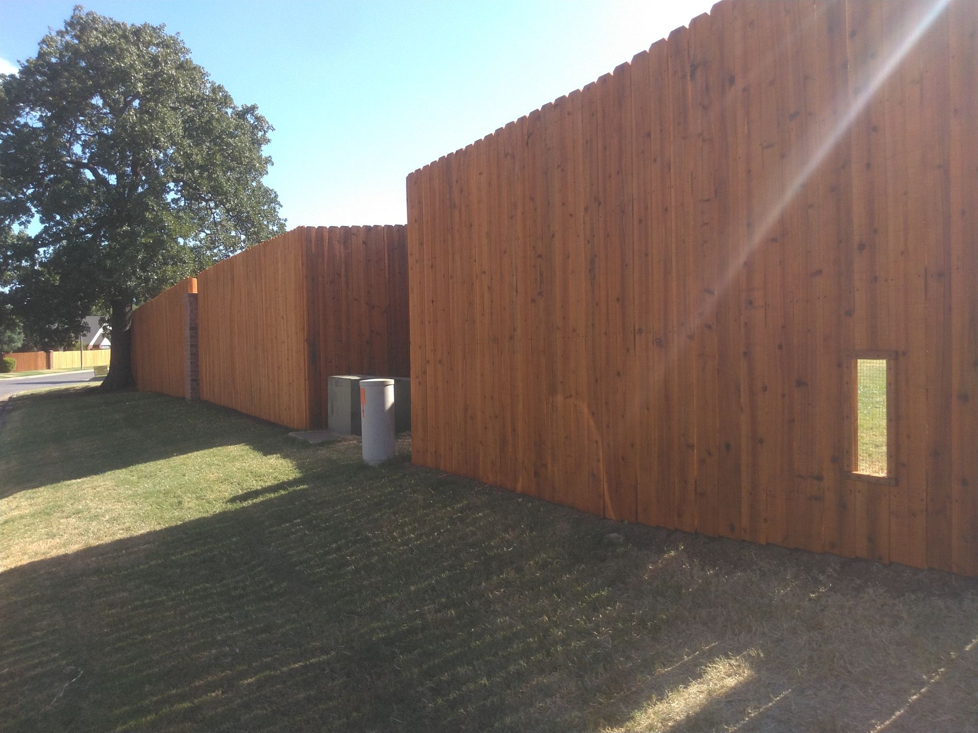 A wooden fence with a hole in the middle of it