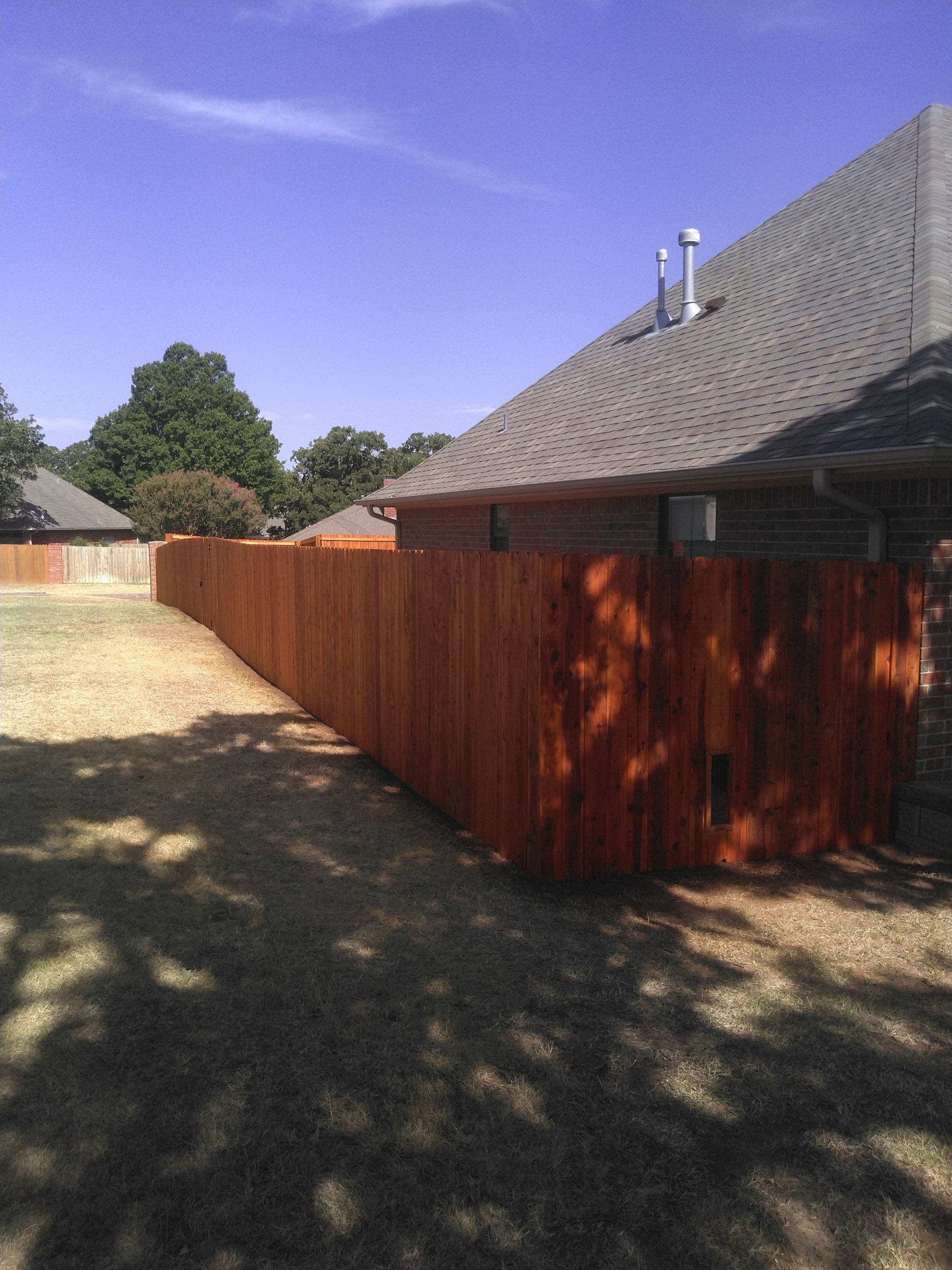 A wooden fence along the side of a house