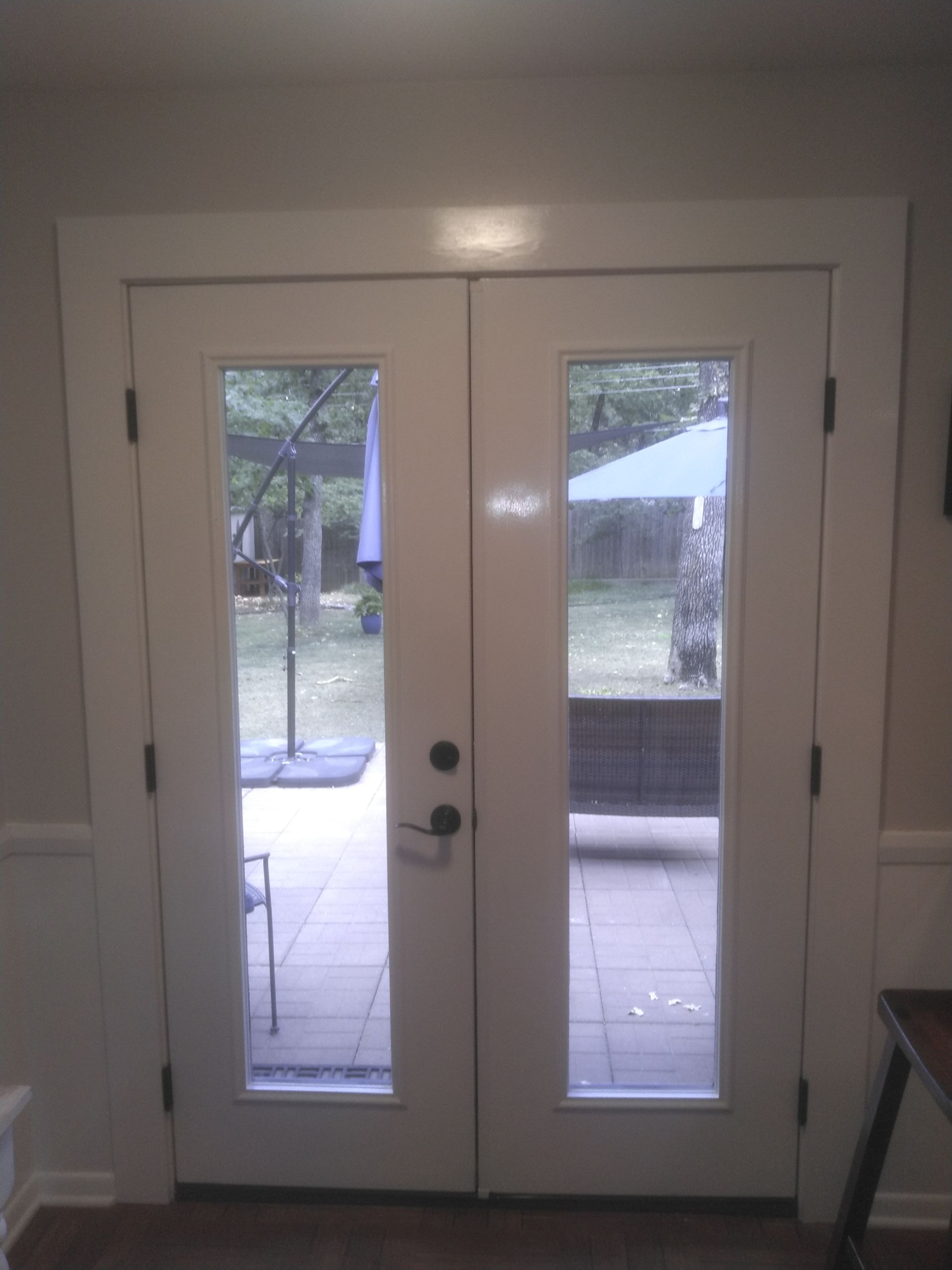 A pair of white french doors open to a patio