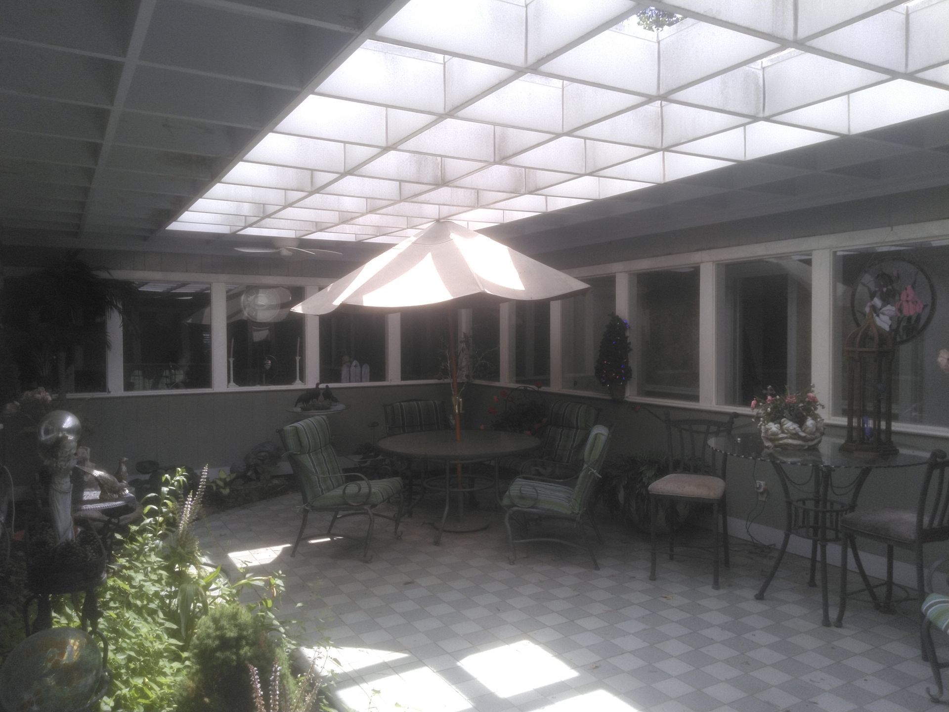 A patio with tables and chairs and an umbrella