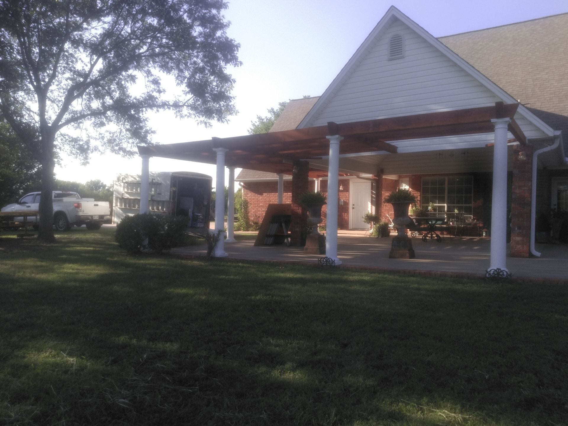 A house with a pergola and a truck parked in front of it