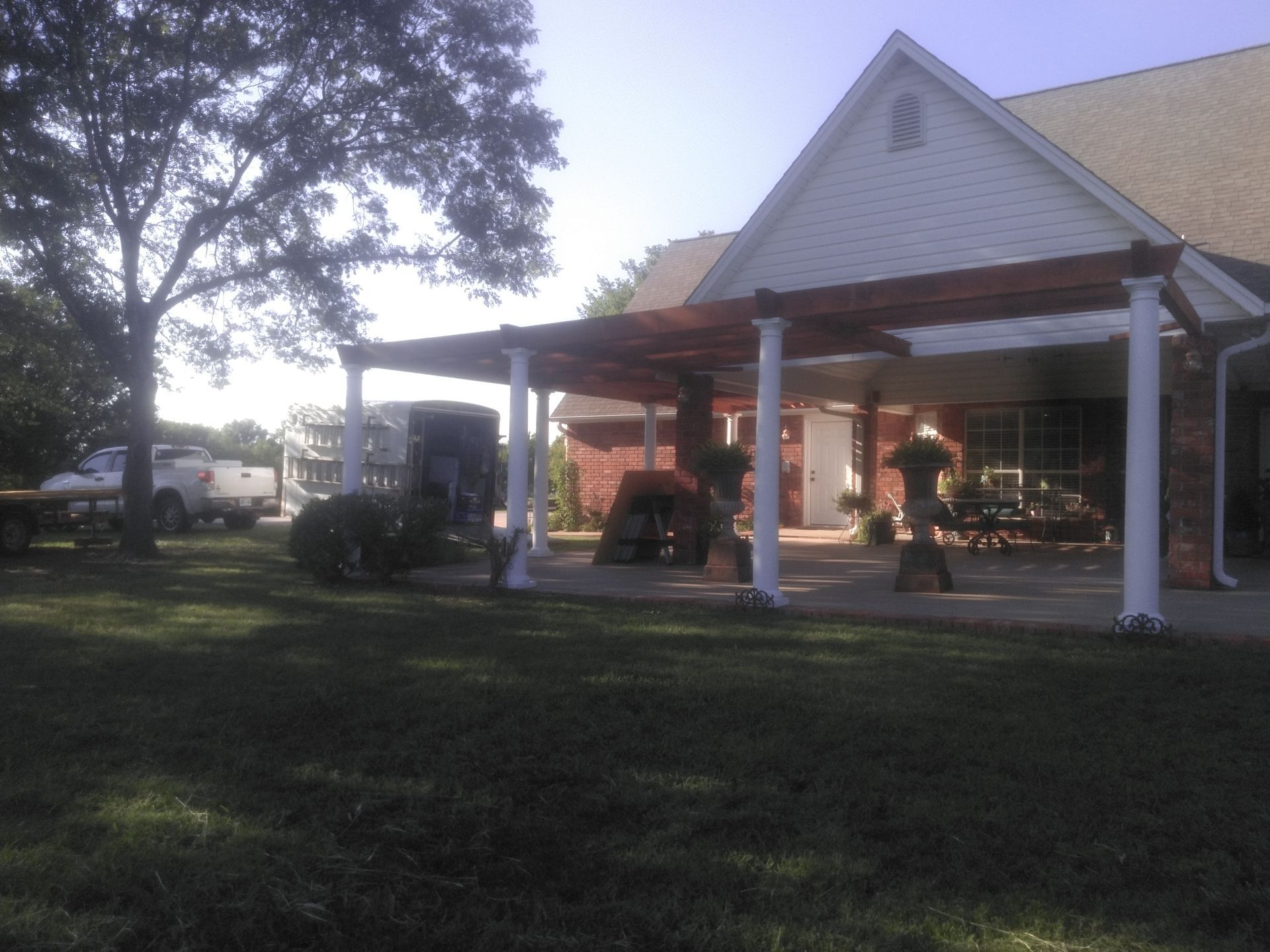 A house with a pergola and a truck parked in front of it