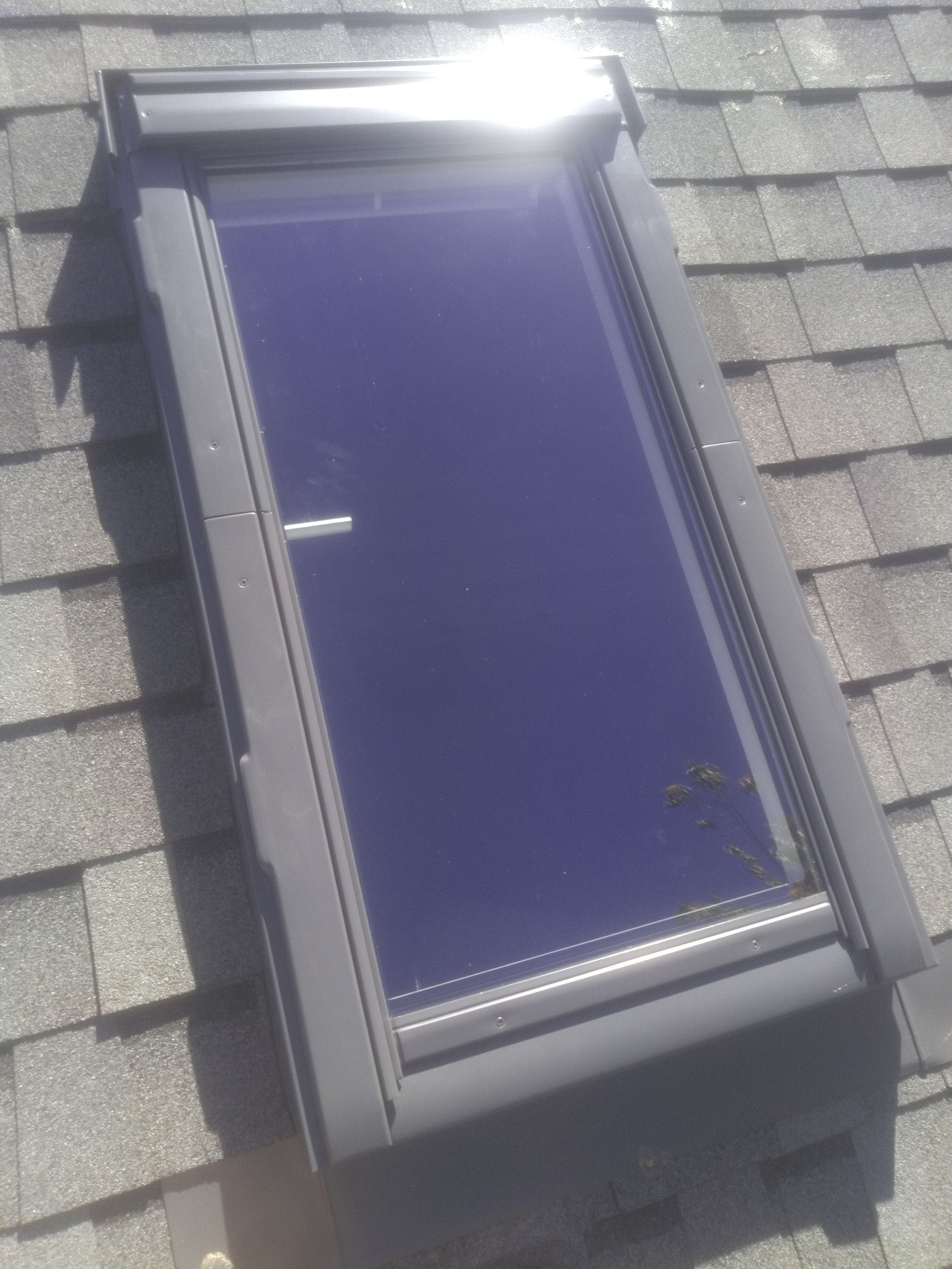 A skylight is sitting on top of a roof.