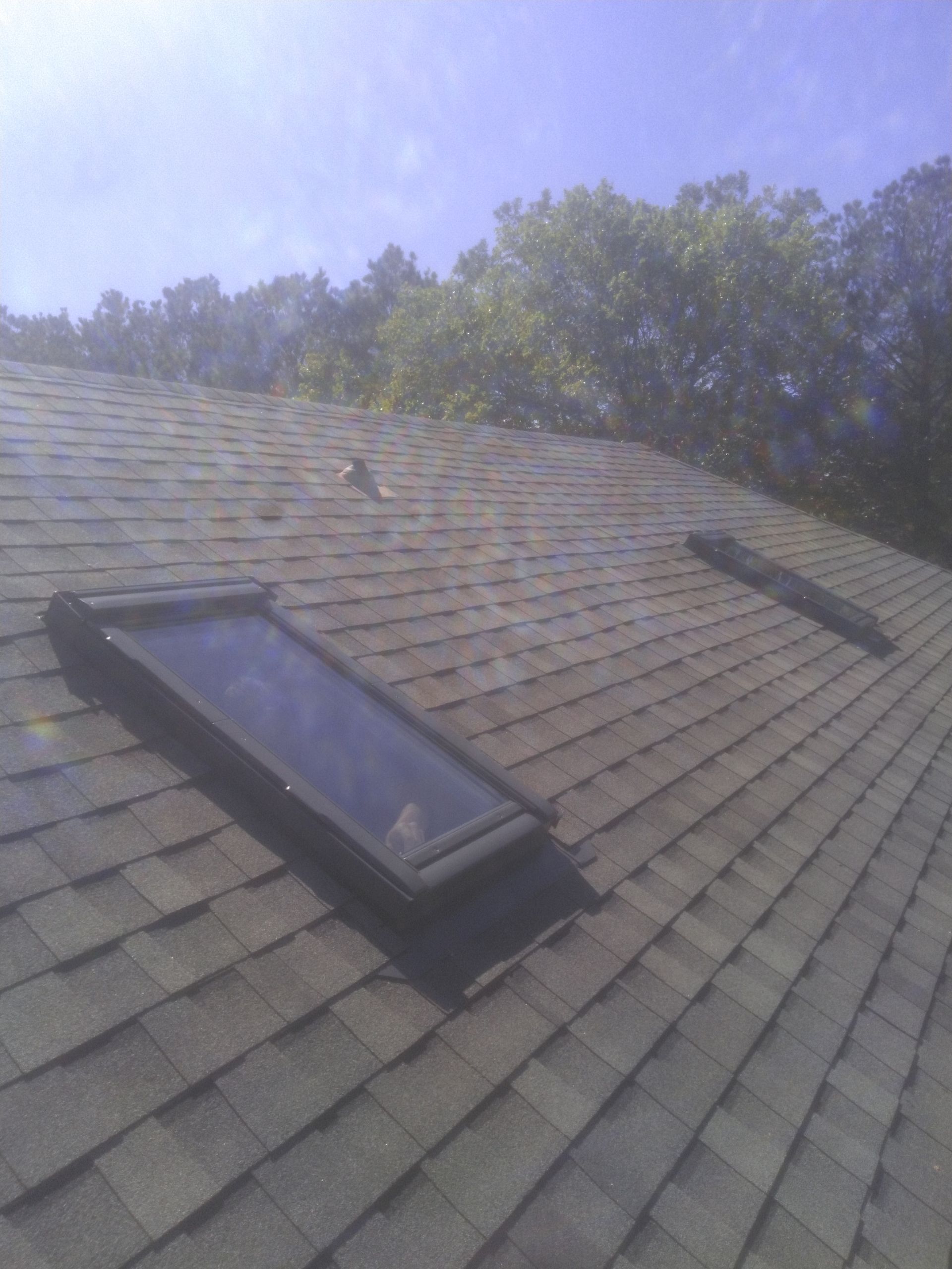 There are two skylights on the roof of a house.