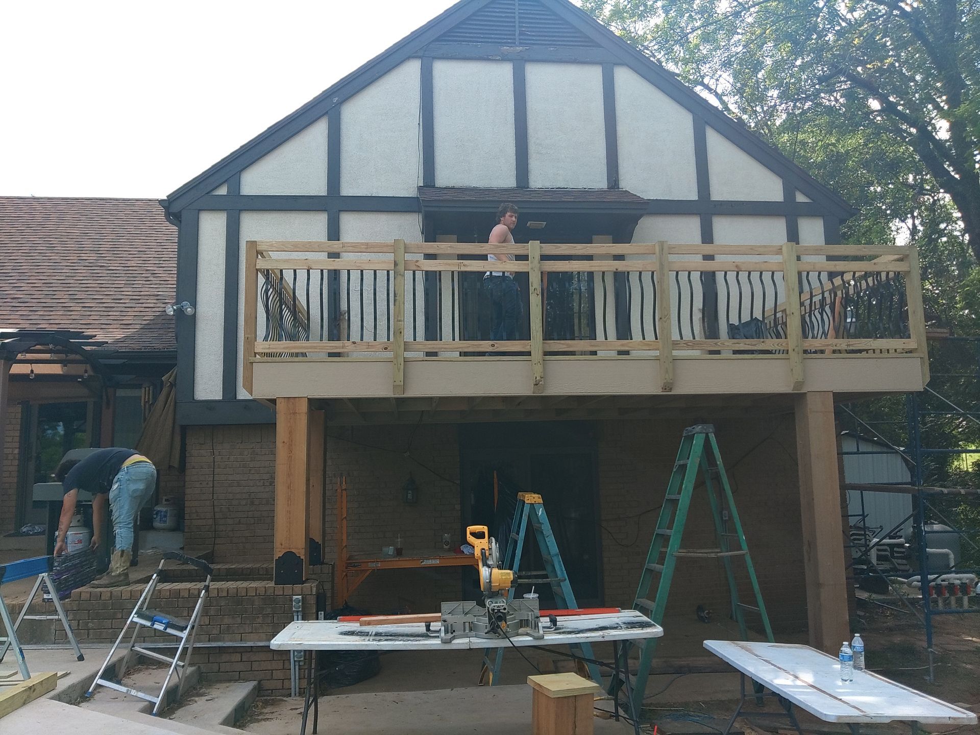 A wooden deck is being built on the side of a house