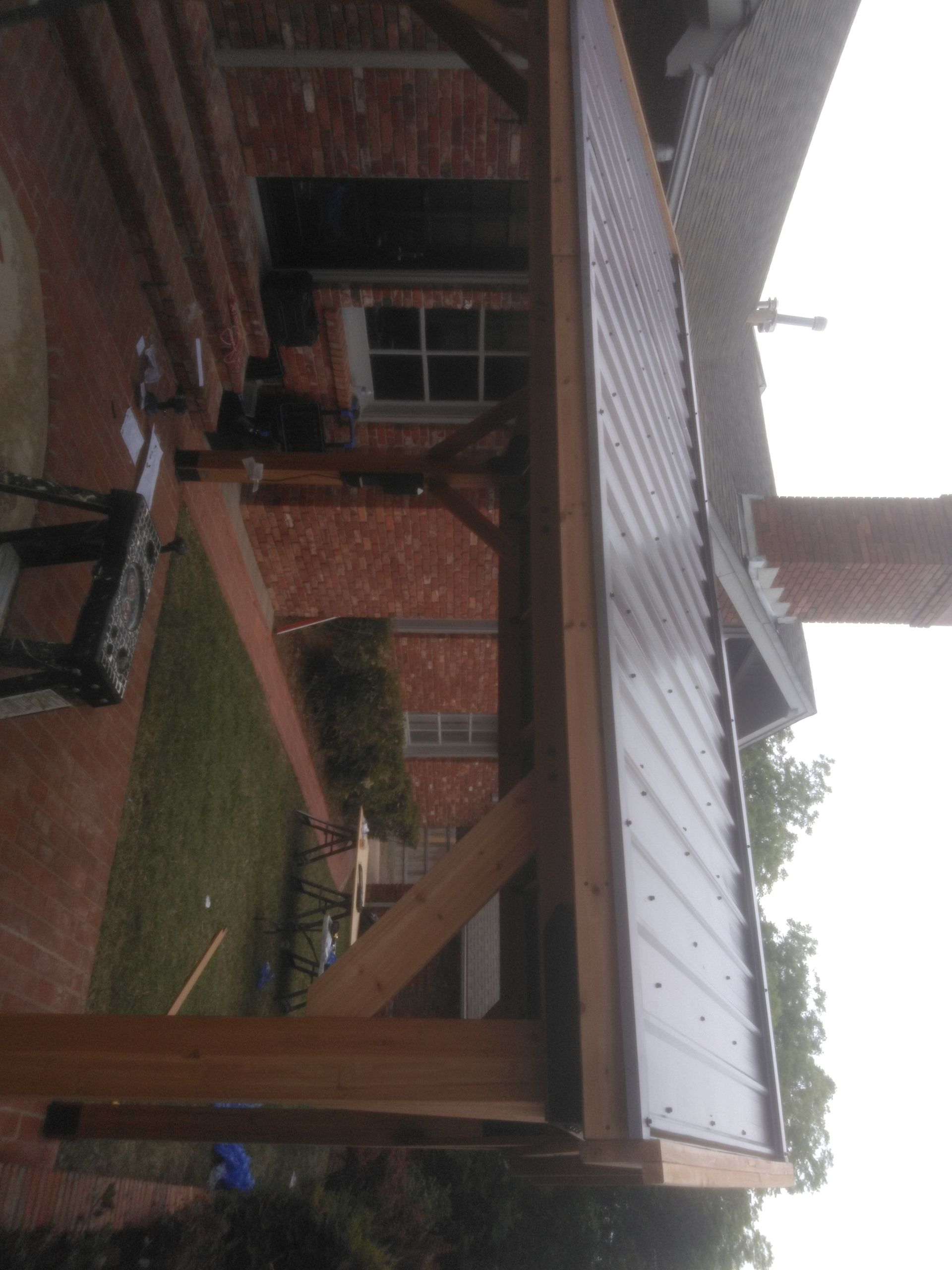 A wooden structure is being built in front of a brick house