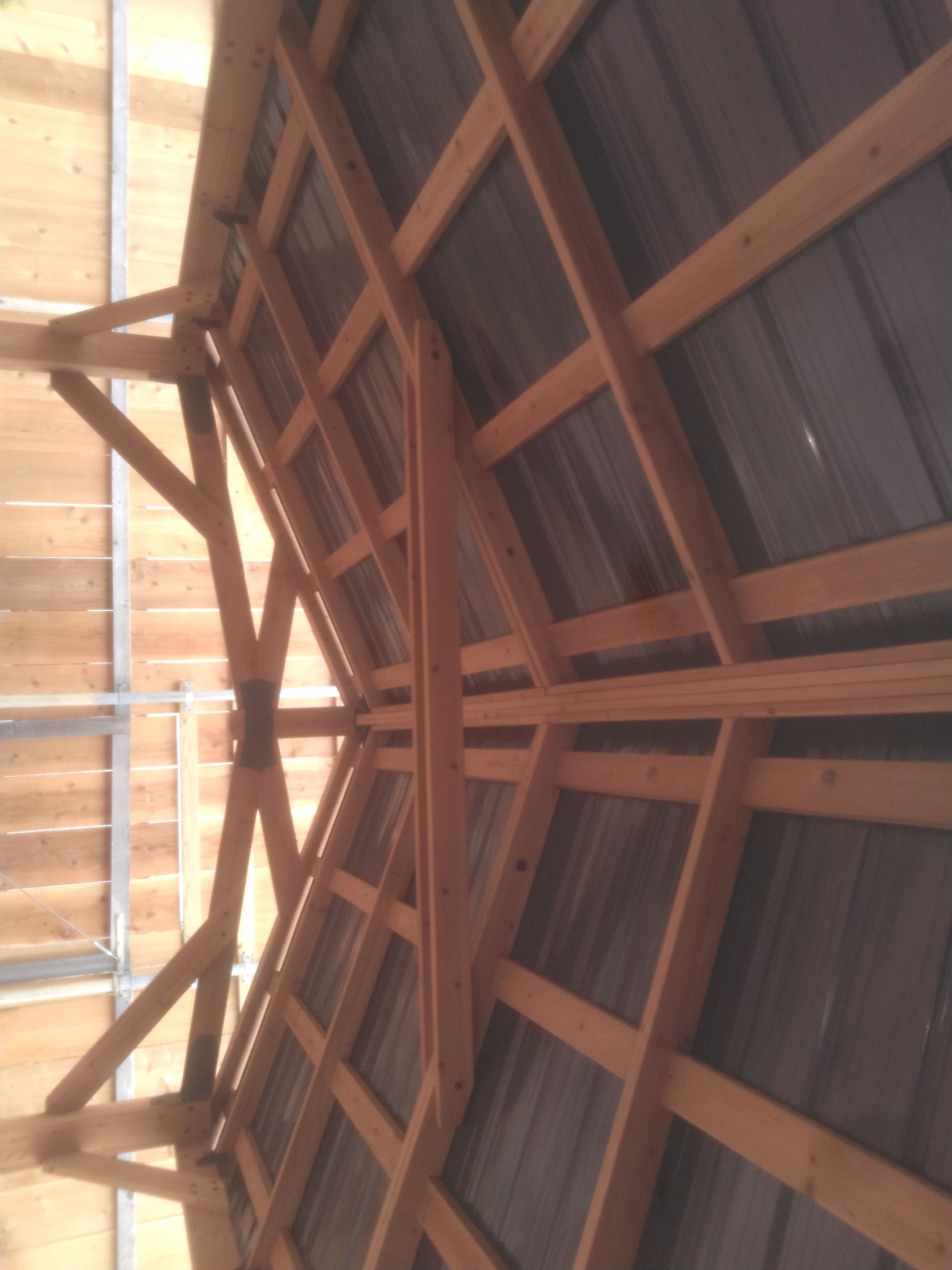 The ceiling of a building is made of wood and metal
