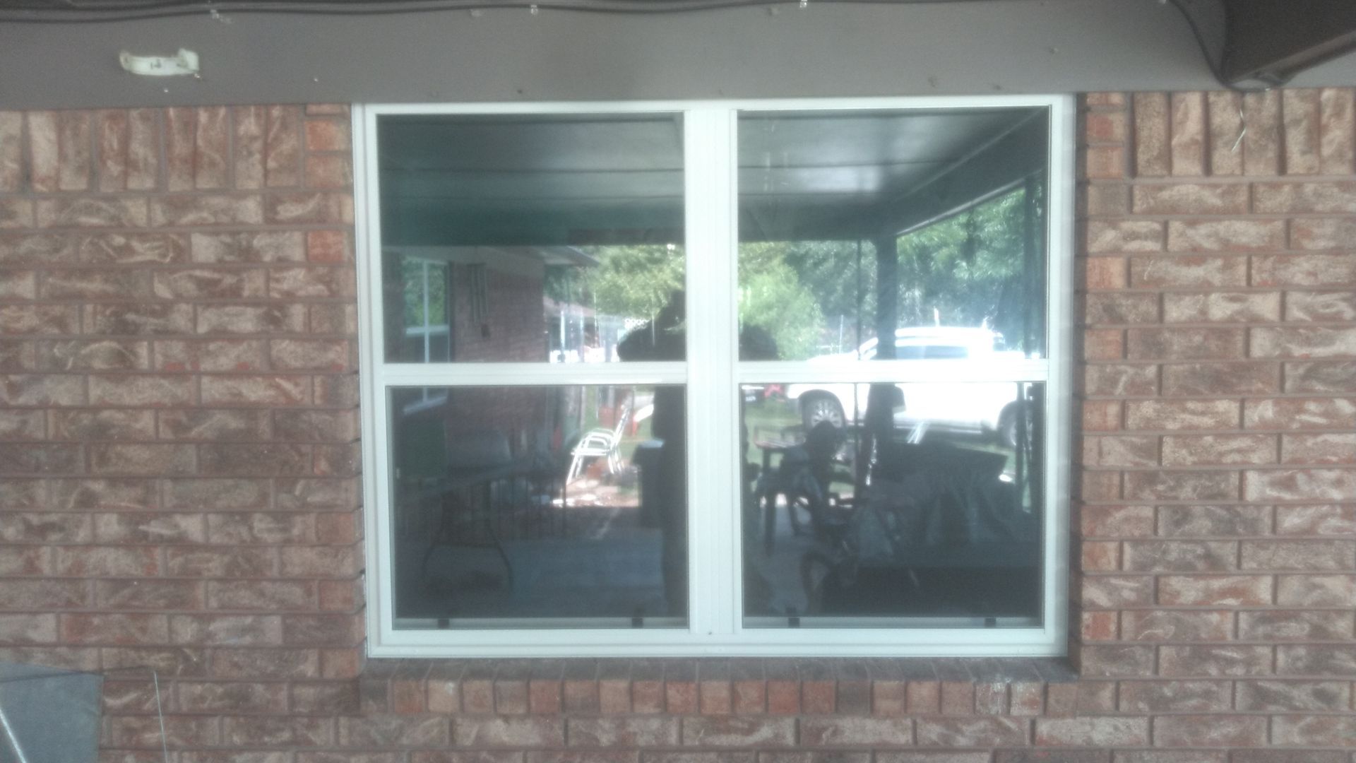 A brick wall with a white window on it.