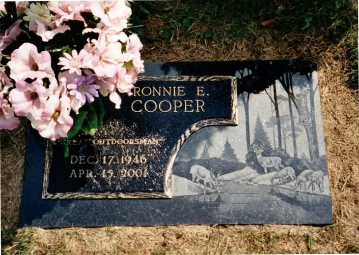 Gravestone for Ronnie E. Cooper with pink flowers at the top left.