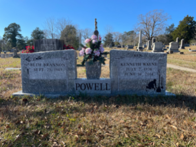 Two granite grave markers with flowers in a cemetery, centered on a Powell family monument