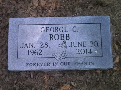 Gray gravestone for George C. Robb with dates Jan. 28, 1962–June 30, 2014 and praying hands engraving