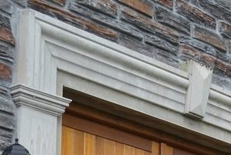 A brick building with a wooden door and a white trim
