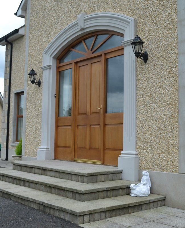 A statue of a lion sits on the steps of a house