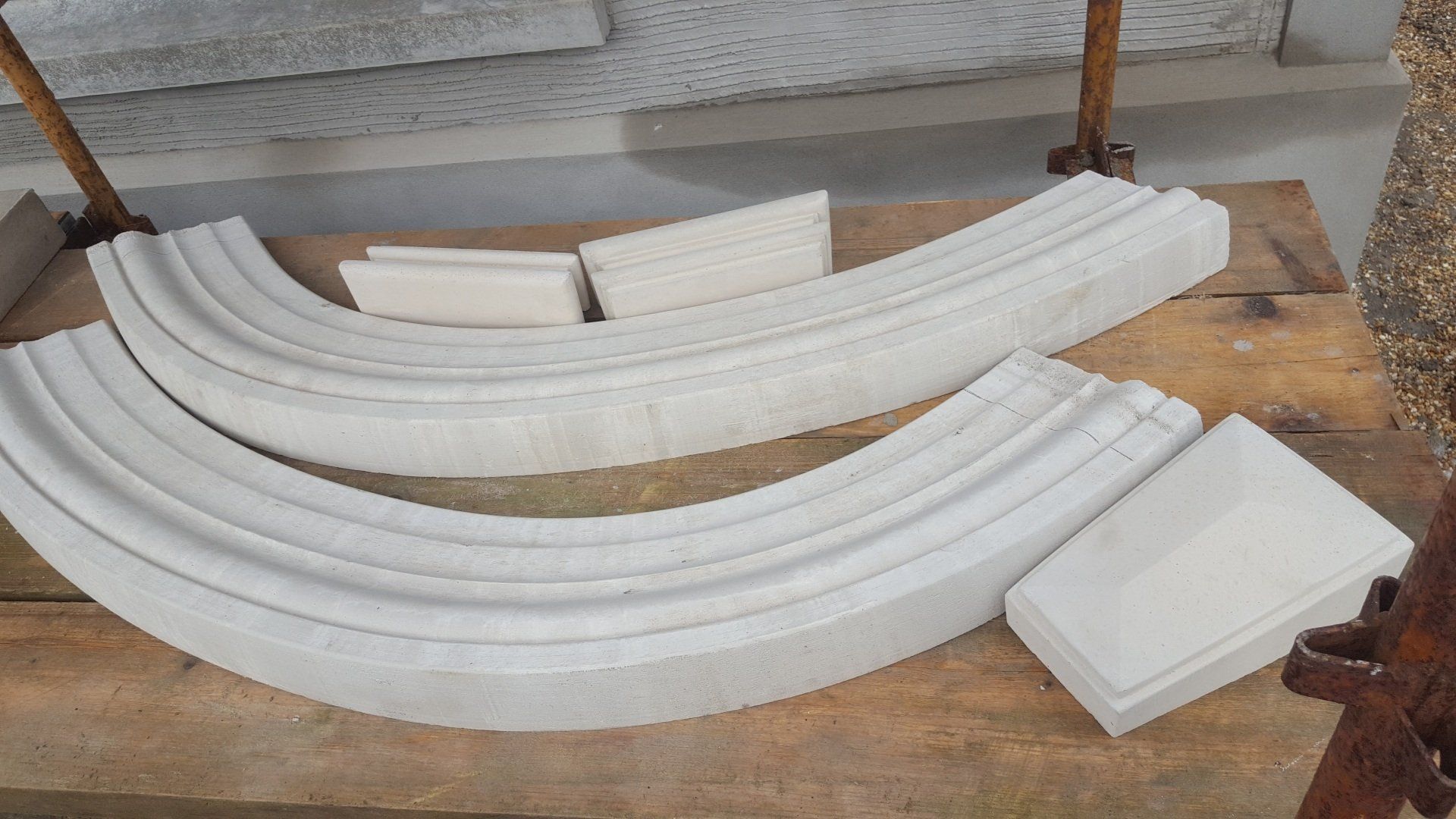 Two curved pieces of concrete are sitting on top of a wooden table.