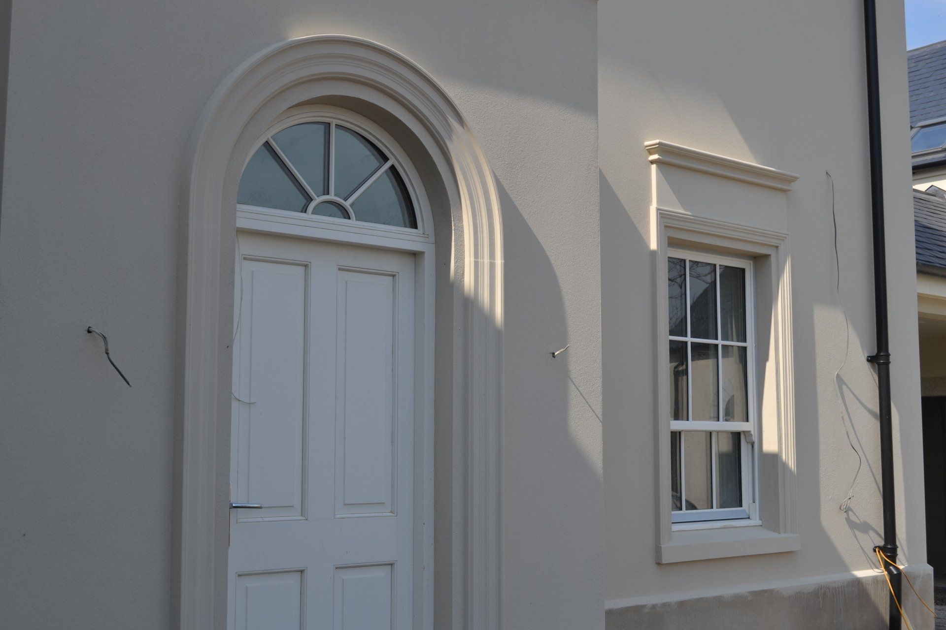 A white door and window on the side of a building.
