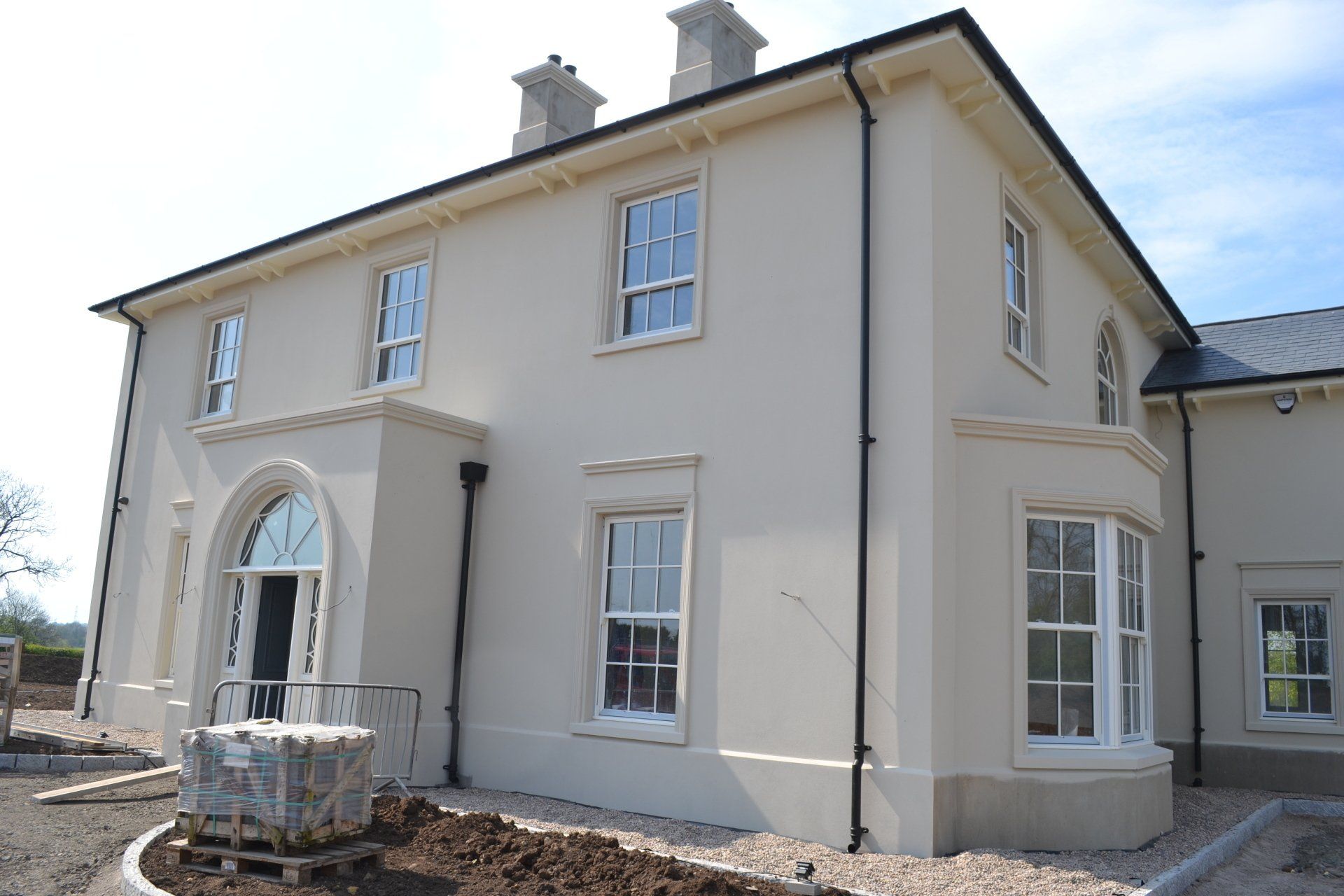 A large white house with a lot of windows is being built.