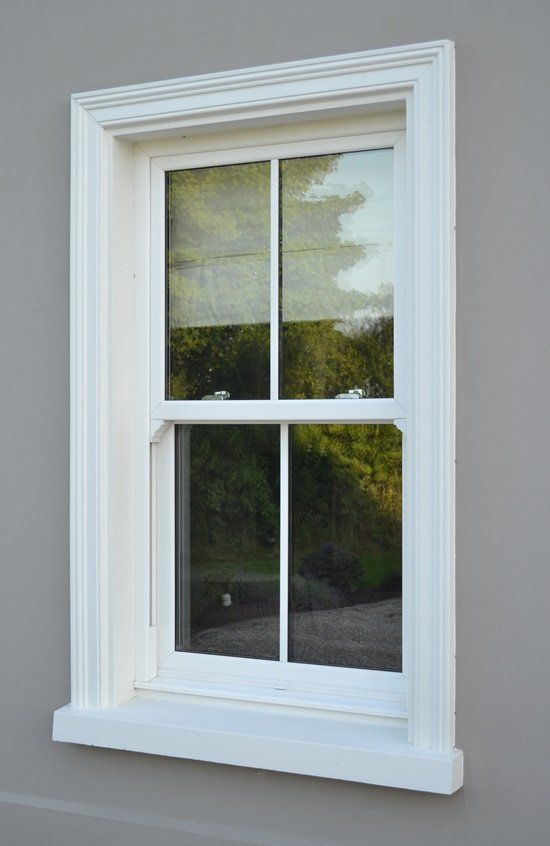 A white window with a white frame is on a gray wall.