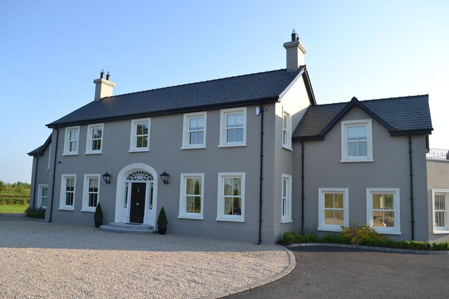 A large house with a gravel driveway in front of it
