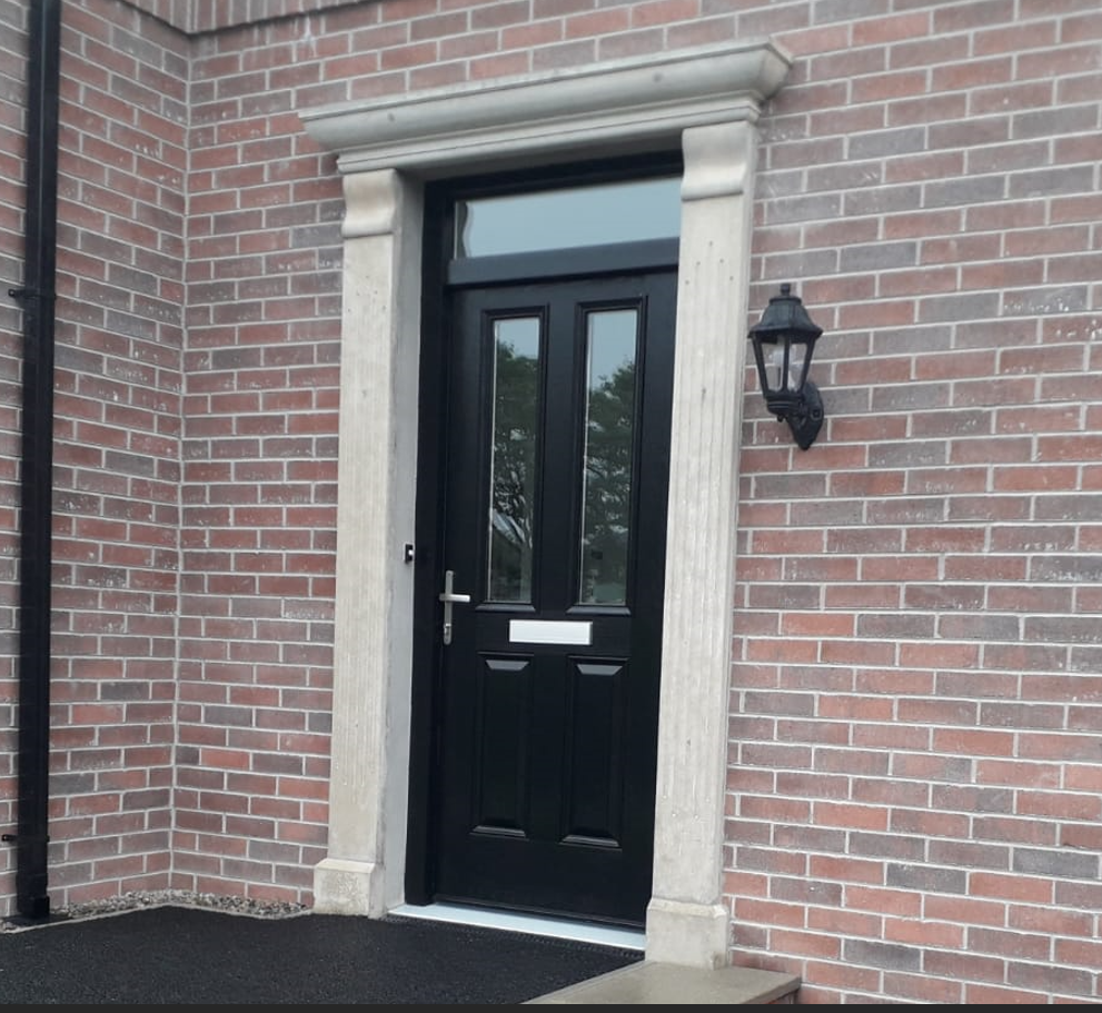 A brick building with a black door and a lamp