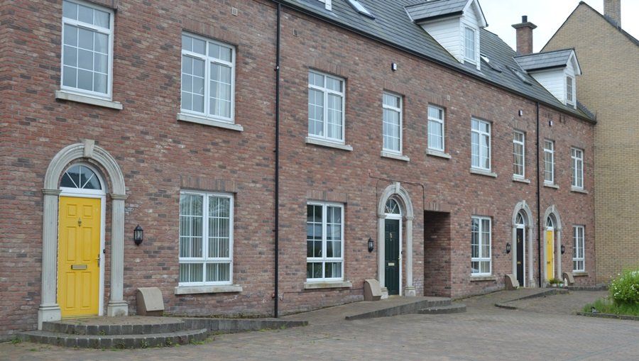 A row of brick houses with yellow doors and windows