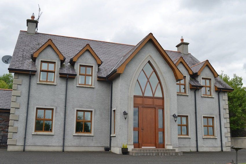 A large grey house with a wooden door and windows