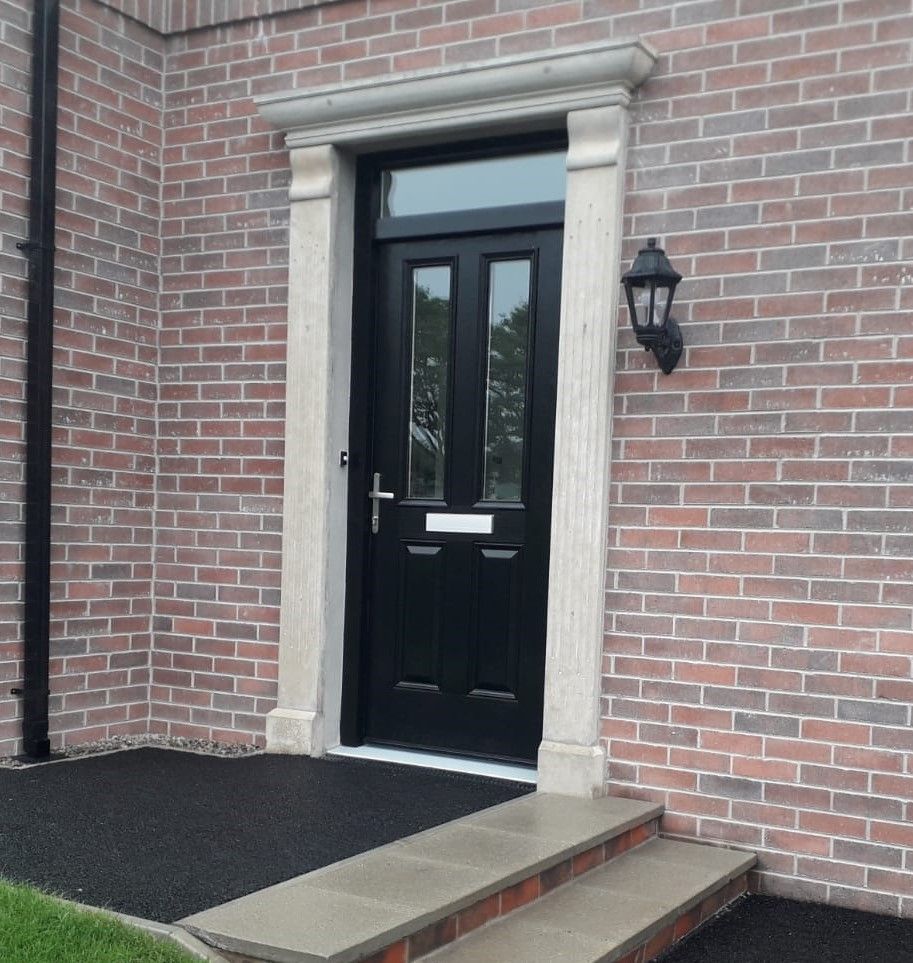 A brick building with a black door and steps