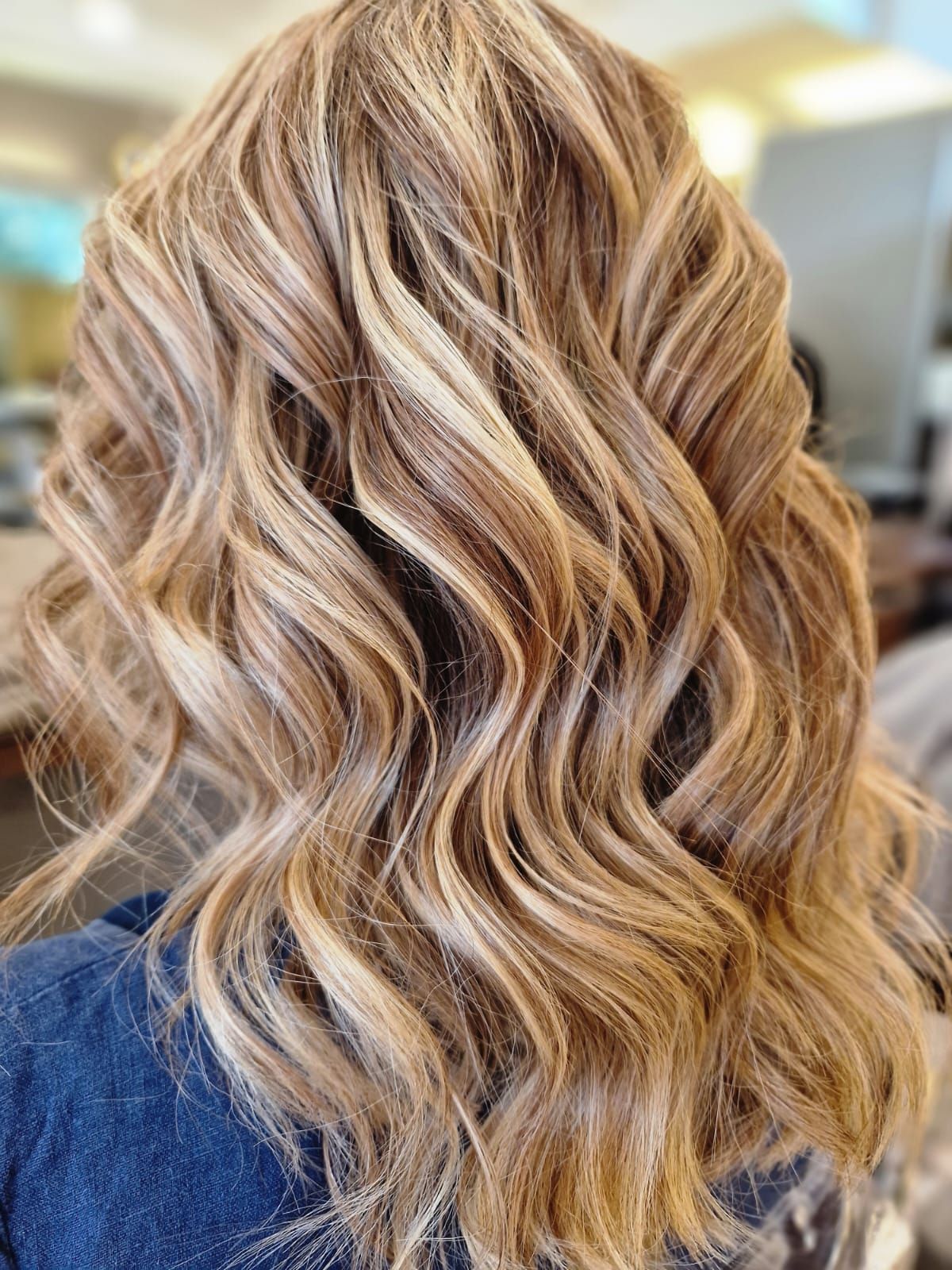 Capelli biondi ondulati con mèches.