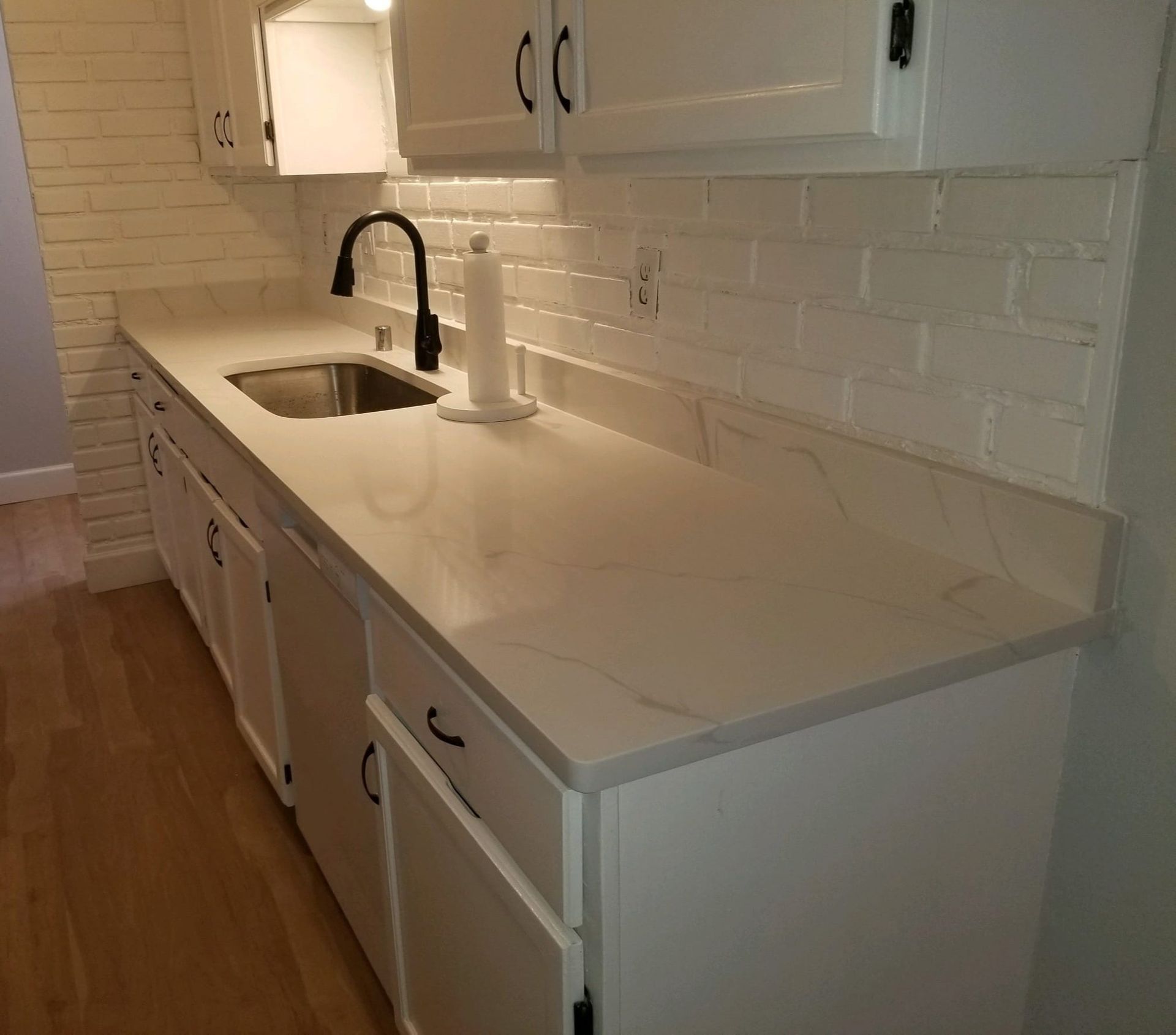 A kitchen with white cabinets and a sink