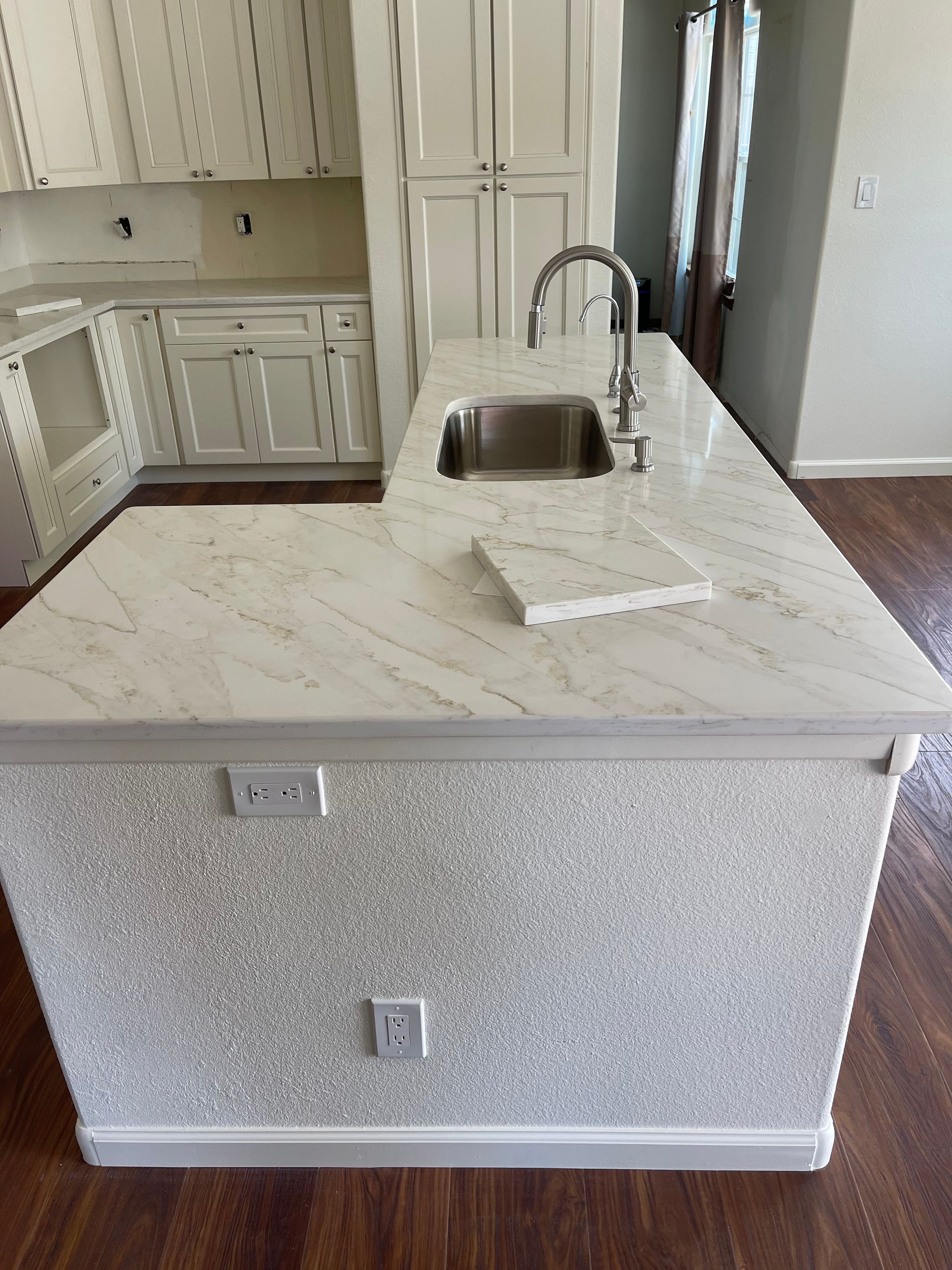 Kitchen island with a marble-patterned countertop and a sparkly, light-colored side panel.
