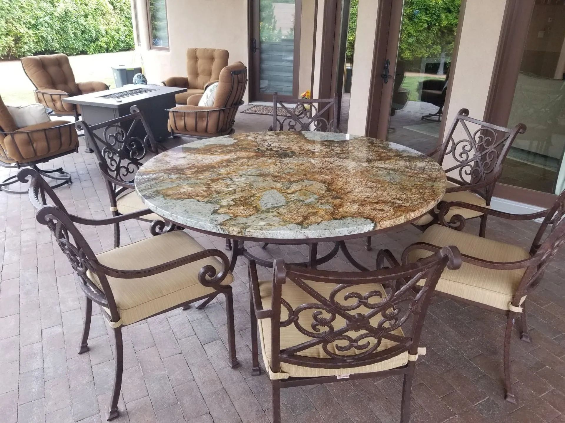 A patio with a table and chairs and a fire pit