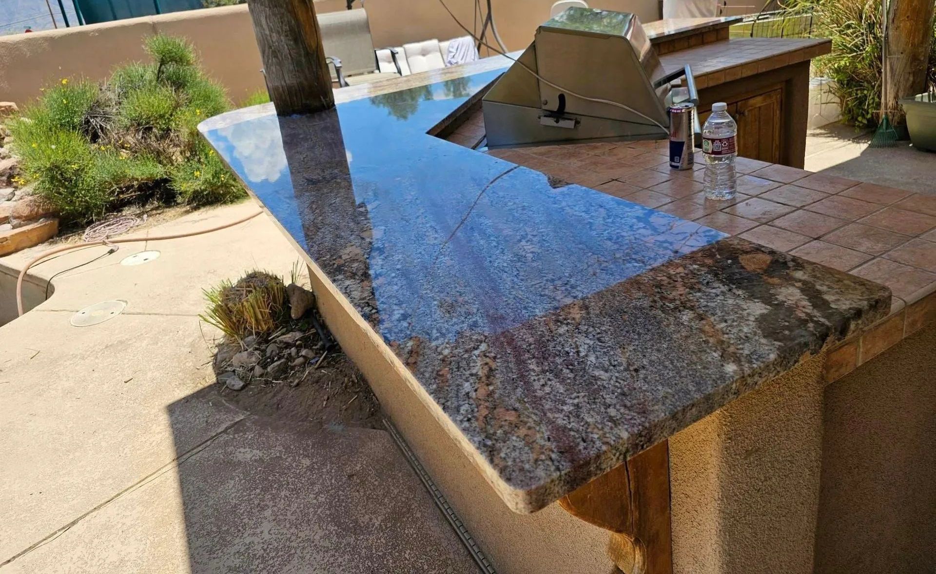 A granite counter top with a bottle of water on it.