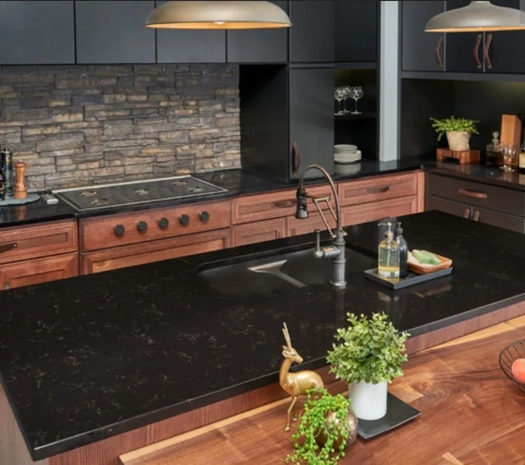 A kitchen with black counter tops and wooden cabinets