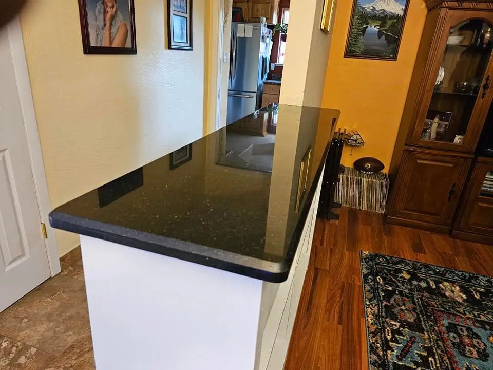 A kitchen with a black granite counter top