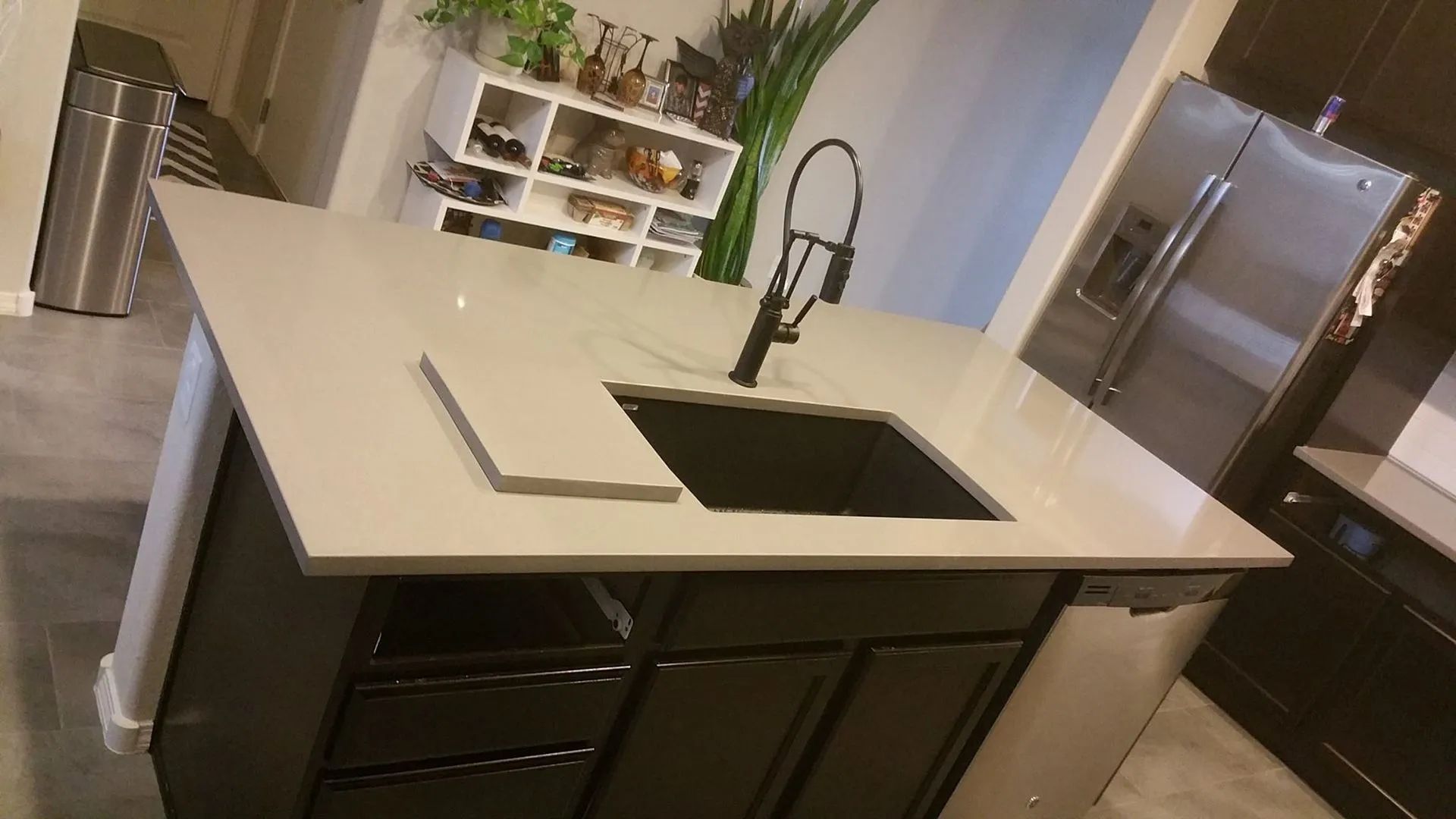 A kitchen with black cabinets and a black sink