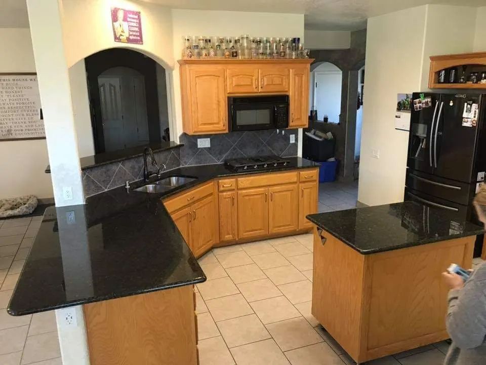 A kitchen with wooden cabinets and black granite counter tops