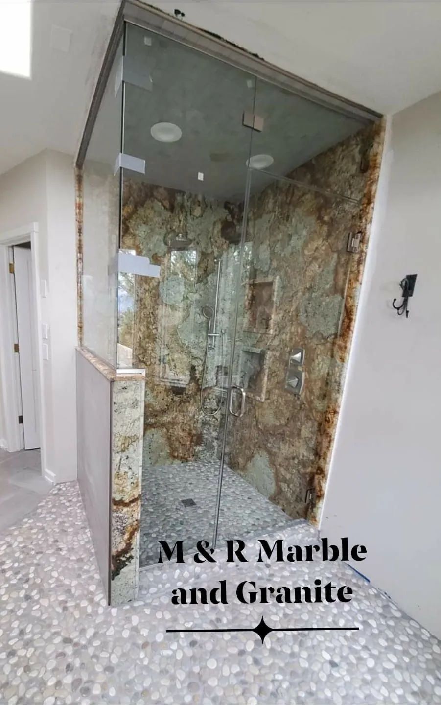 A bathroom with a walk in shower made of marble and granite.