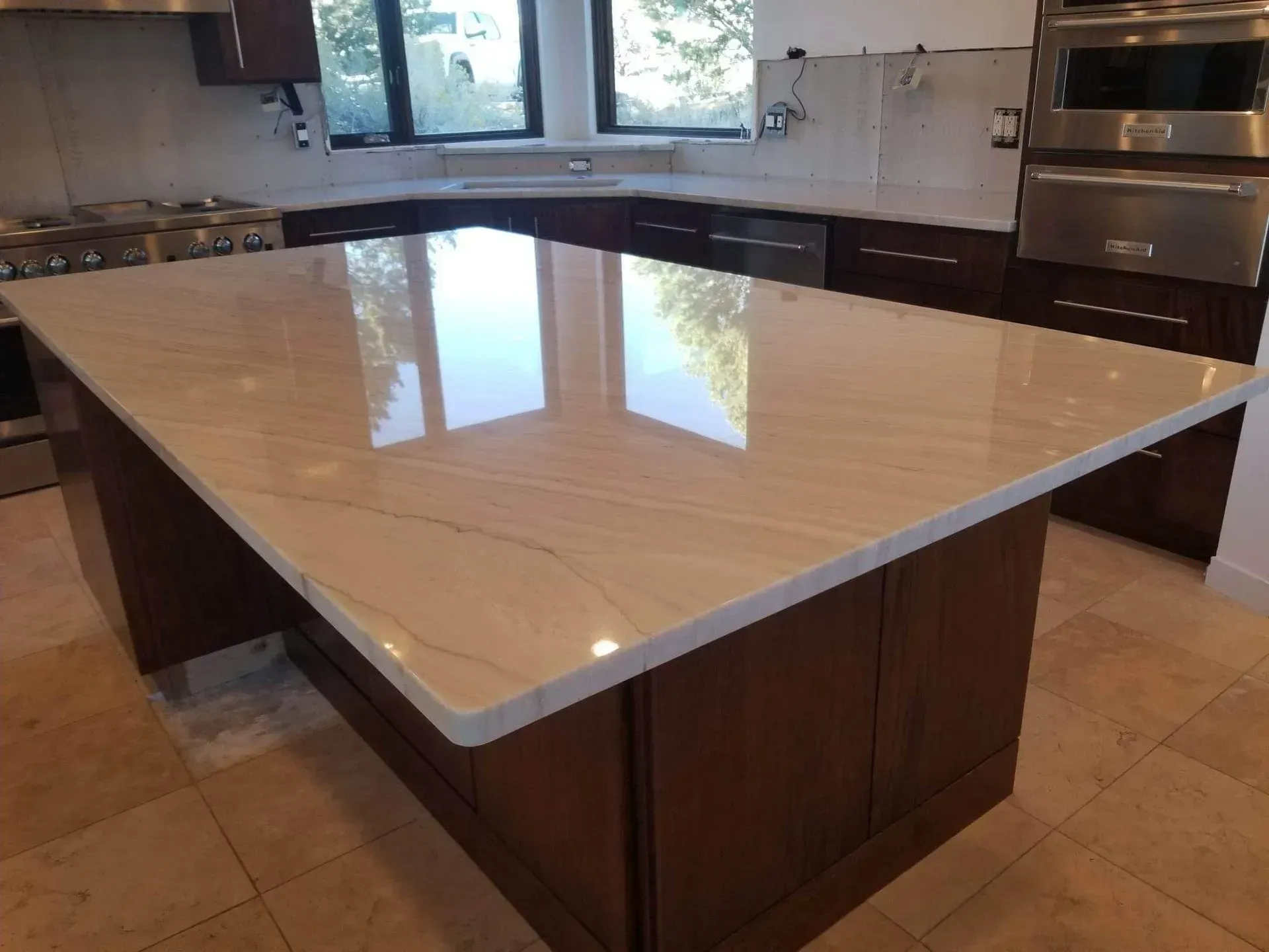 A kitchen with a large island with a marble counter top