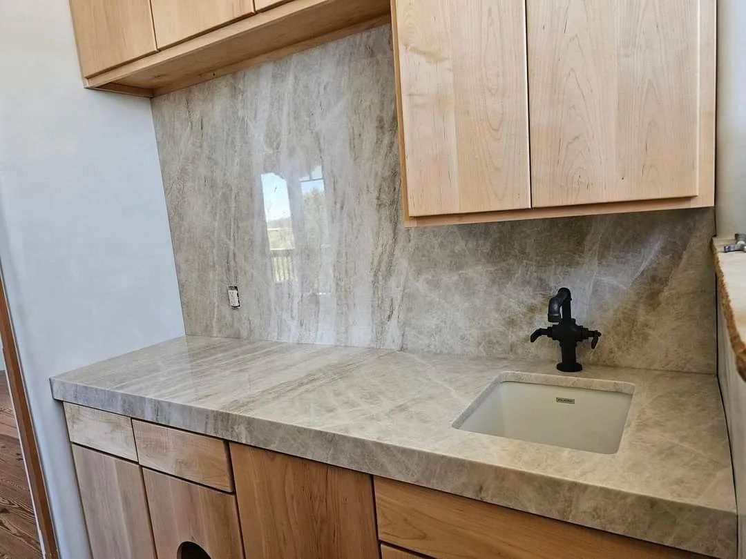 A kitchen counter with a sink and wooden cabinets.