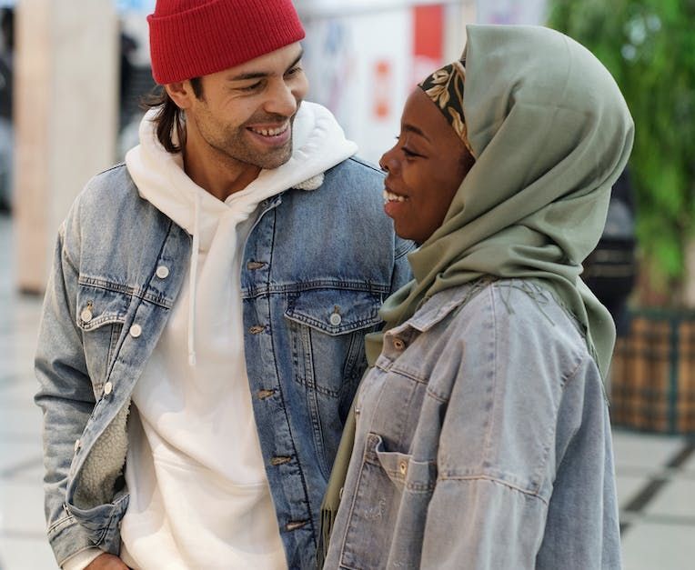 A man and a woman are standing next to each other and looking at each other.