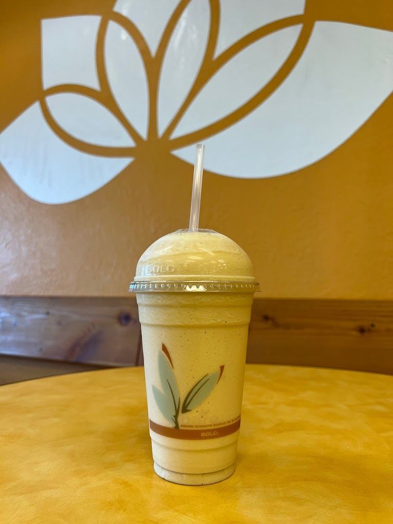 A smoothie in a cup with a straw on a table